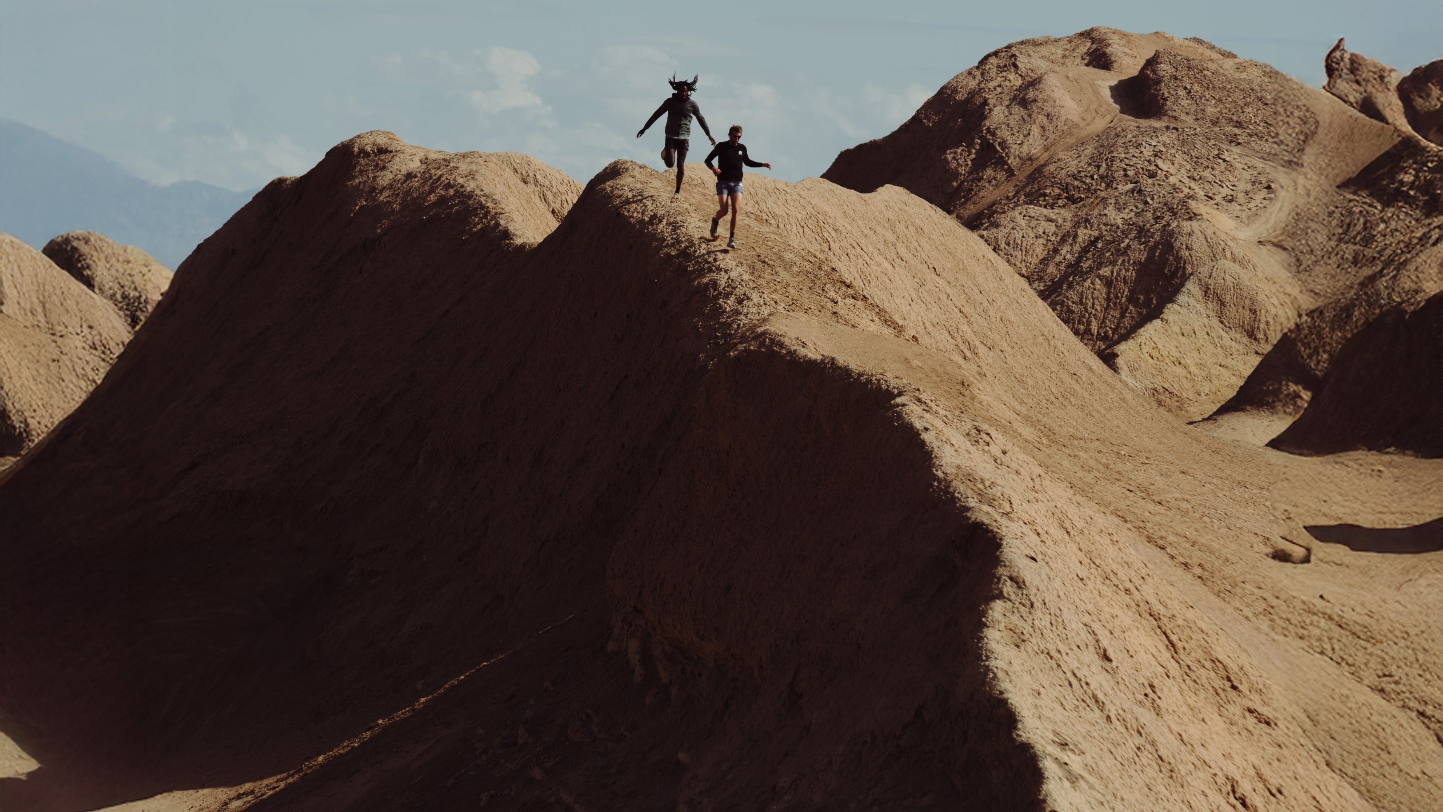 Banner image of adventurer exploring the rugged Badlands terrain, embodying the spirit of adventure in a dramatic geological setting, perfect for the outdoor enthusiast.