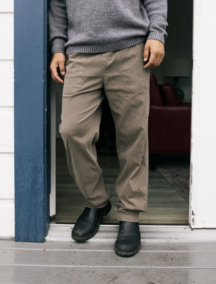 Assorted adventure-ready pants including khaki and denim styles with visible pockets and buttons, perfect for outdoor and travel activities by Roark.