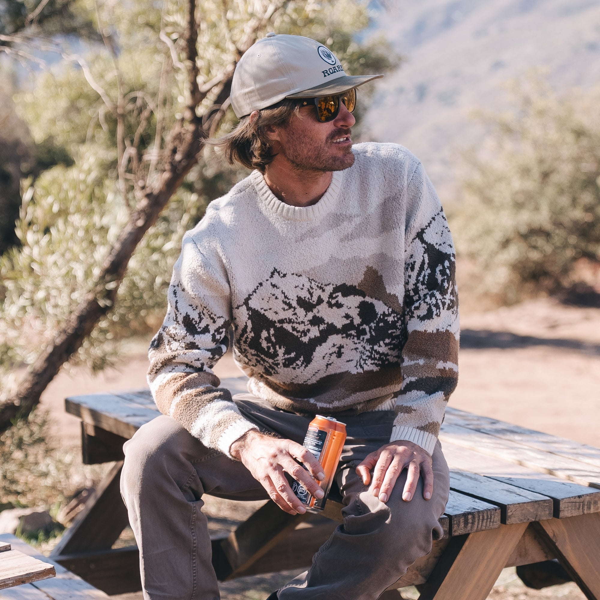 Person in camouflage cap from the Tierra del Sur Collection, ideal for adventurous travel and outdoor activities.