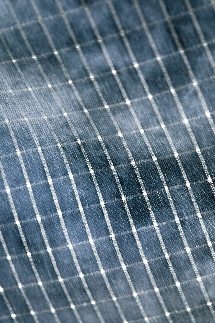 Slate blue fabric with white pinstripe pattern showing HOLEYTECH™ breathable weave texture detail