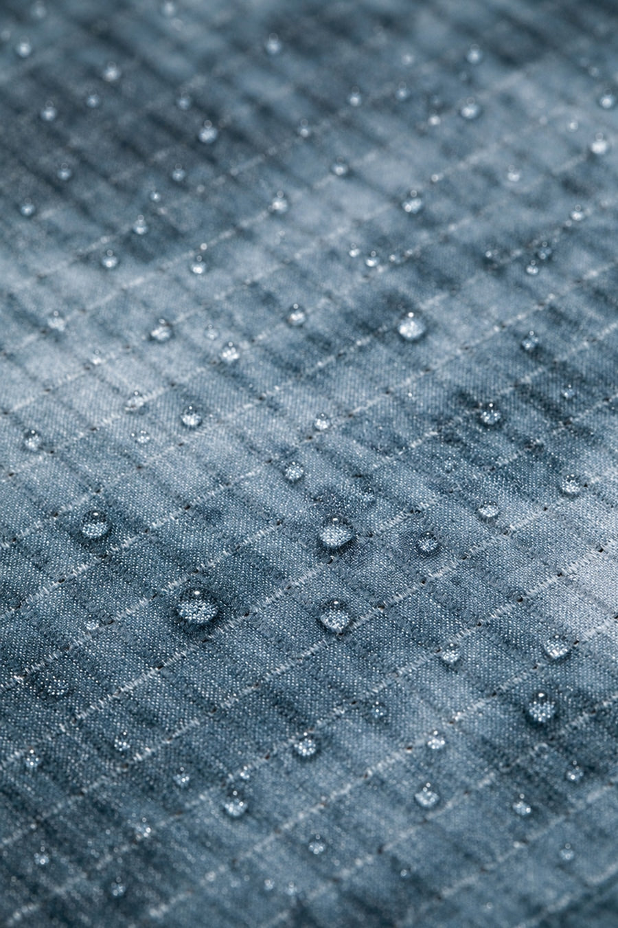 Water droplets bead on blue quilted fabric with water-resistant coating technology