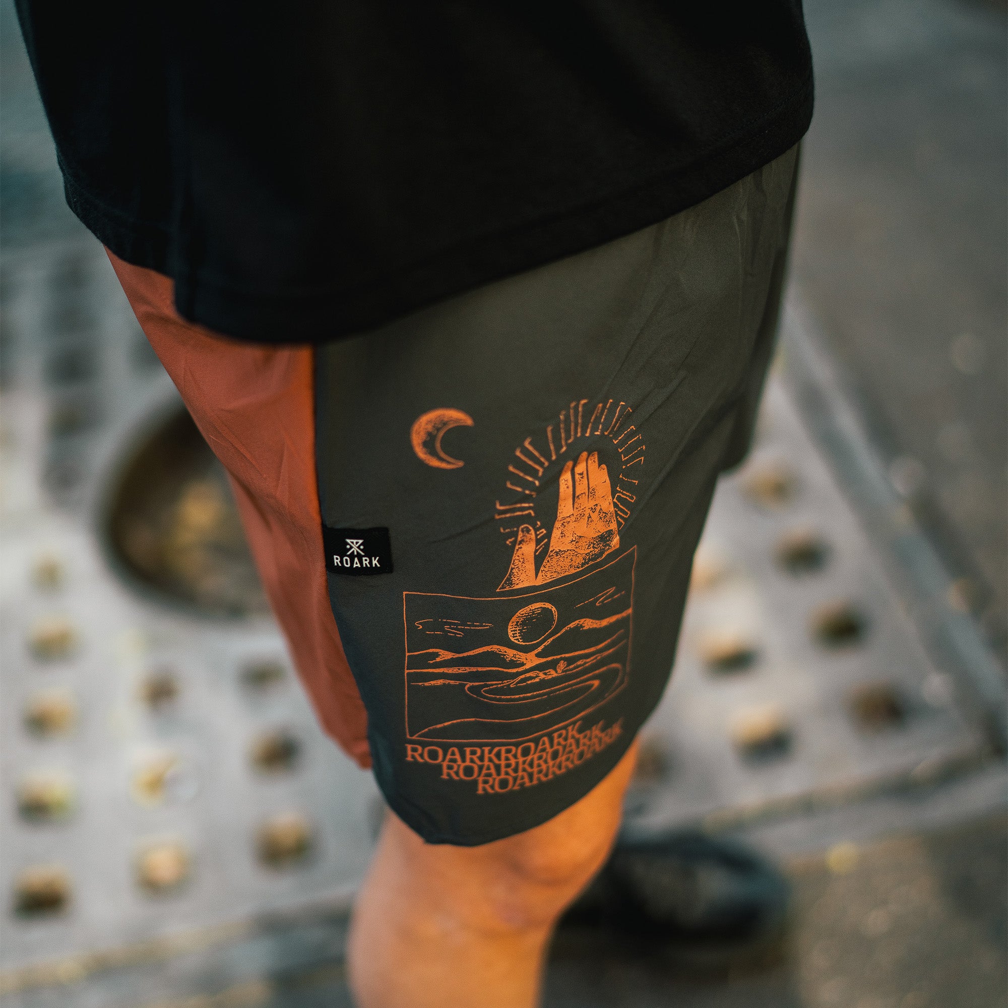 Roark Alta 5 boardshorts displayed on a serene beach setting, perfect for adventure and travel