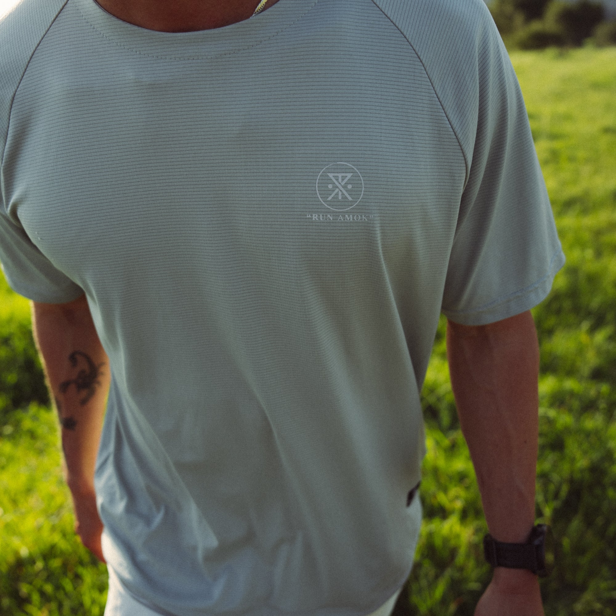 Active trail runner wearing a Roark Alta Elite Trail Short Sleeve Tee, designed for outdoor adventures, showing details like the fabric texture and fit on the shoulders and neck.