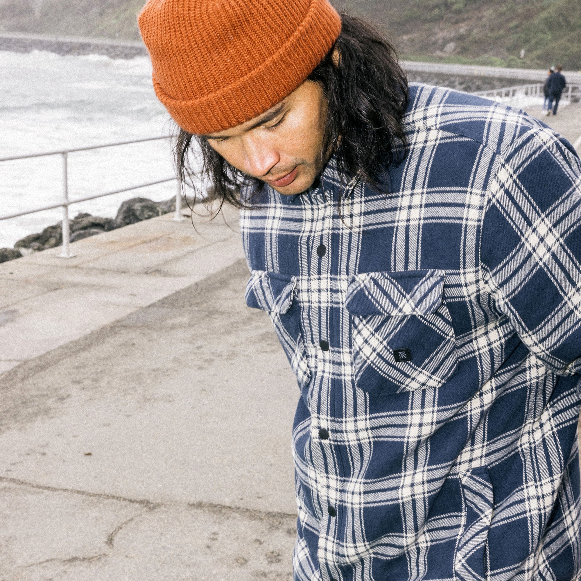 Outdoor adventurer wearing a plaid Backwoods Overshirt Jacket paired with denim, styled with a knit beanie, embodying Roark's spirit of travel and exploration.