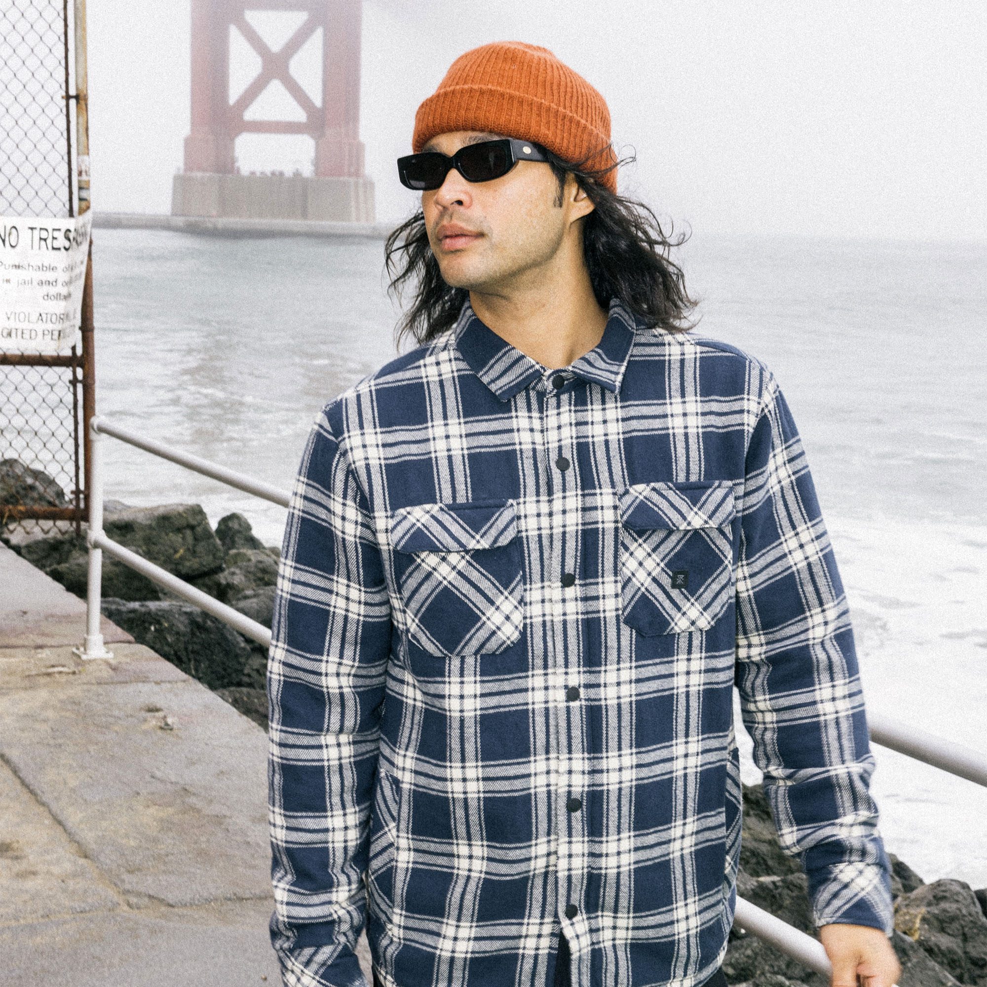 Rugged plaid flannel overshirt jacket with denim sleeves, perfect for outdoor adventures and travel, in traditional tartan pattern.