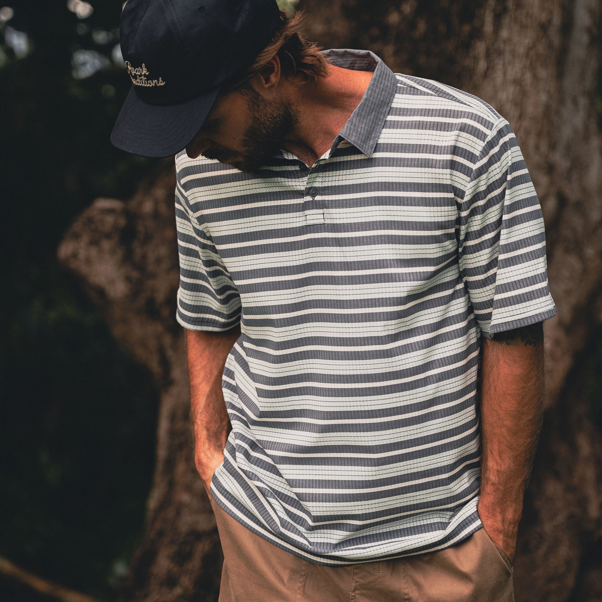 Man in Bless Up Polo wearing a cap, styled for outdoor adventure and travel