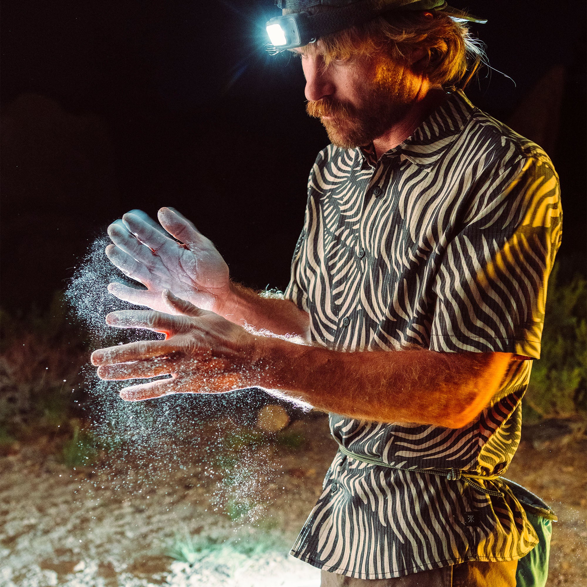 Adventurous man with a full beard and goggles, wearing a cap, epitomizing the rugged, travel-ready style of Roark.