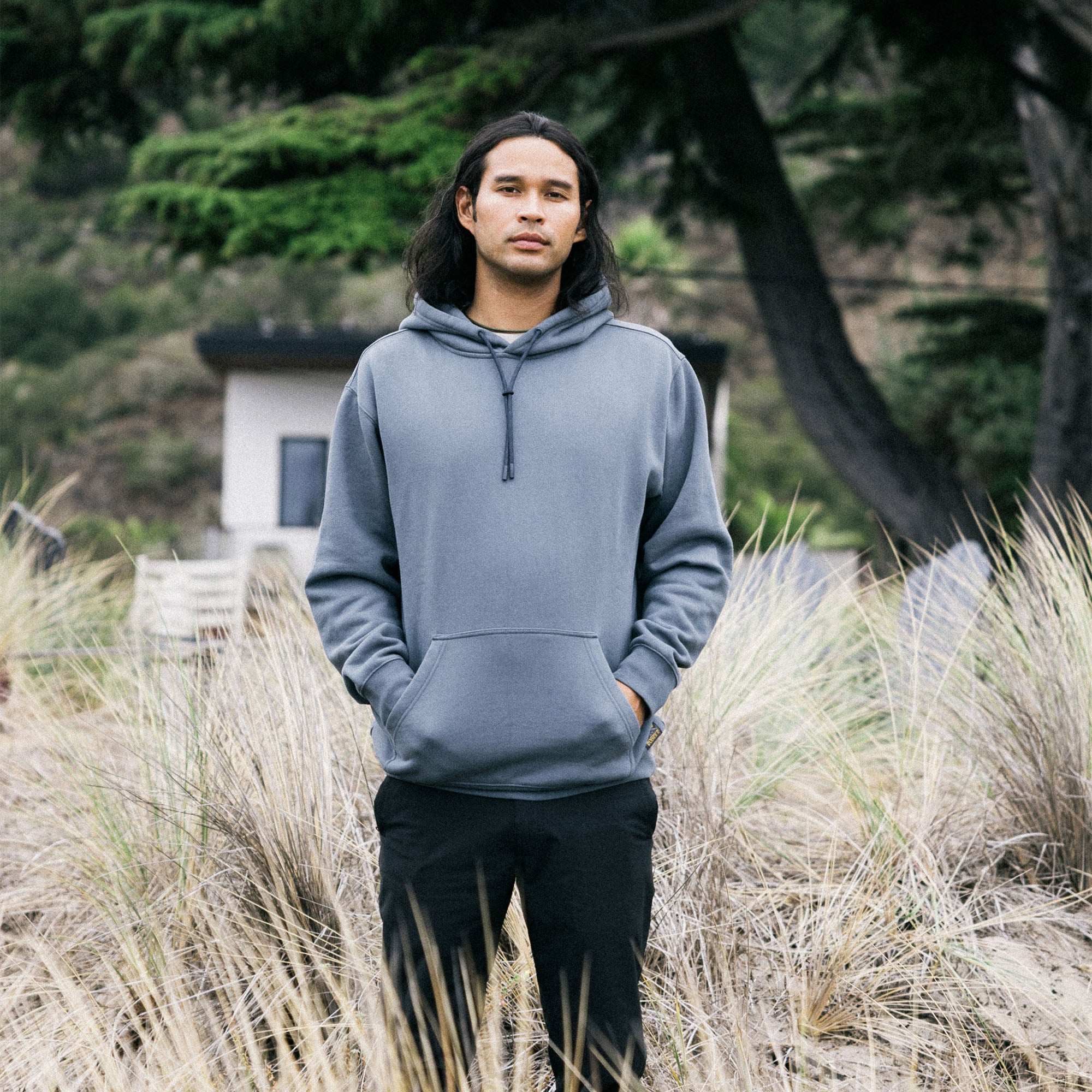 Man wearing a grey Bolo fleece hoodie and active pants casually enjoying a vacation outdoors