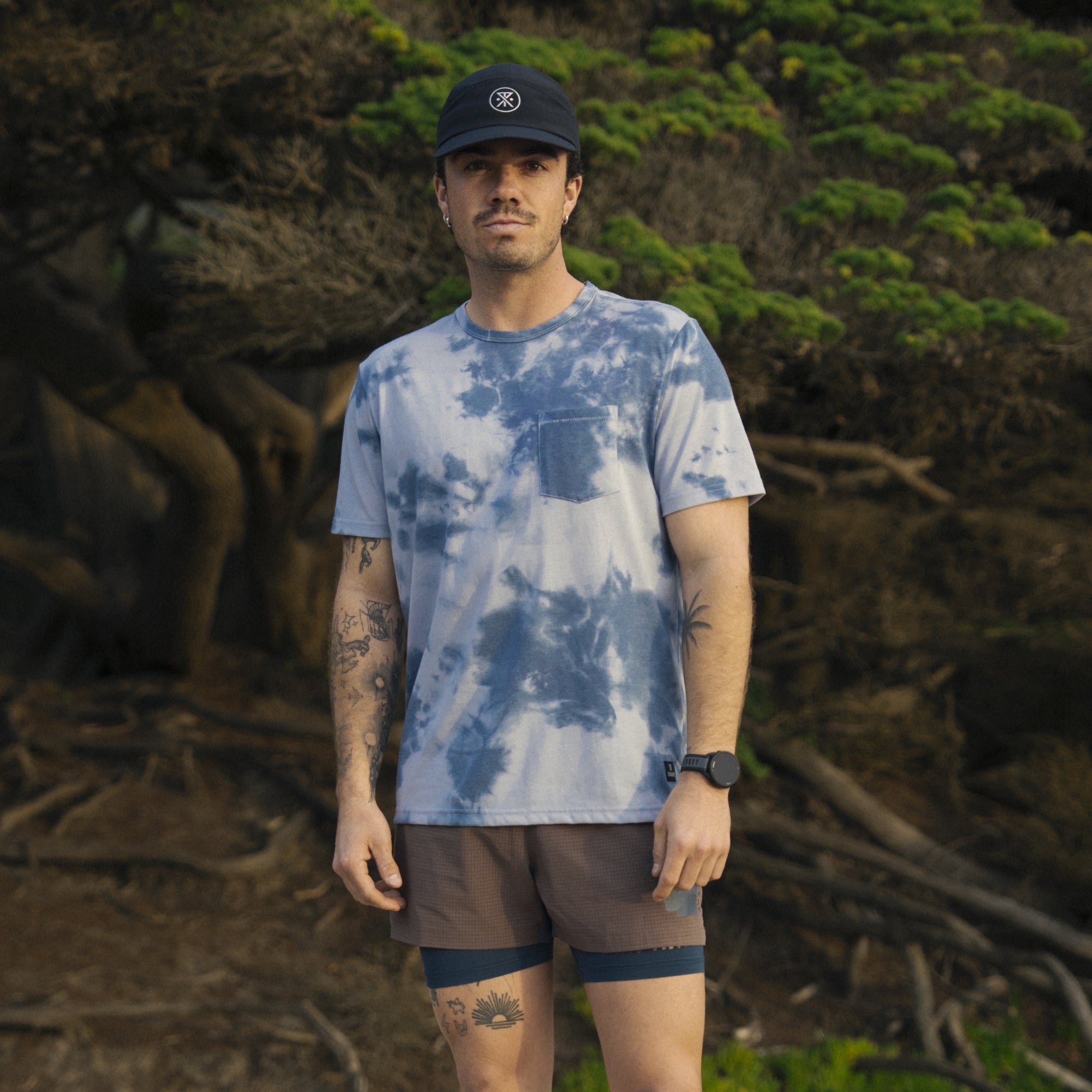 Group of adventurers wearing Roark active shirts and boardshorts exploring nature