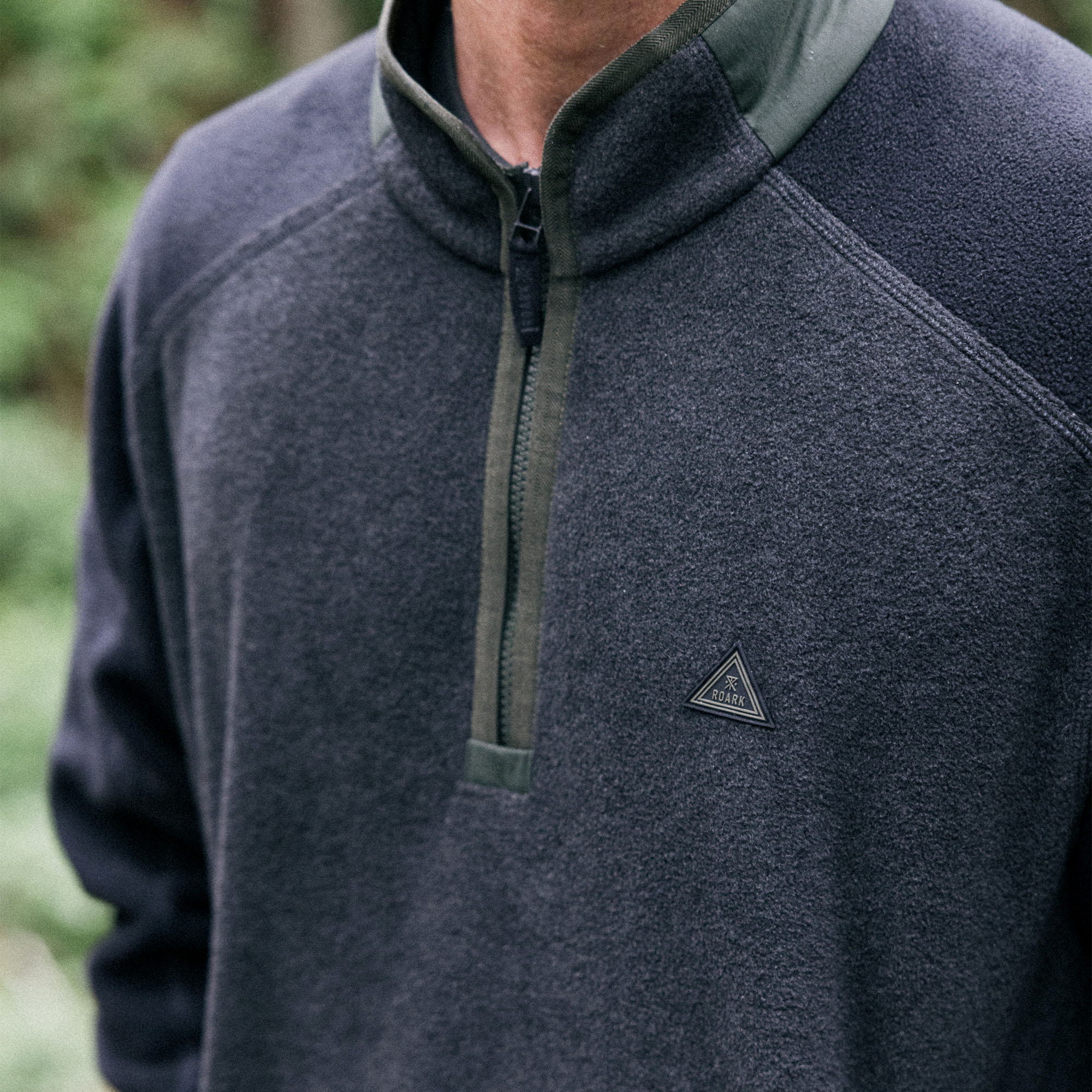 Roark Campover Fleece Mock Hoodie displayed in outdoor natural setting, emphasizing comfort and durability for adventure and travel.