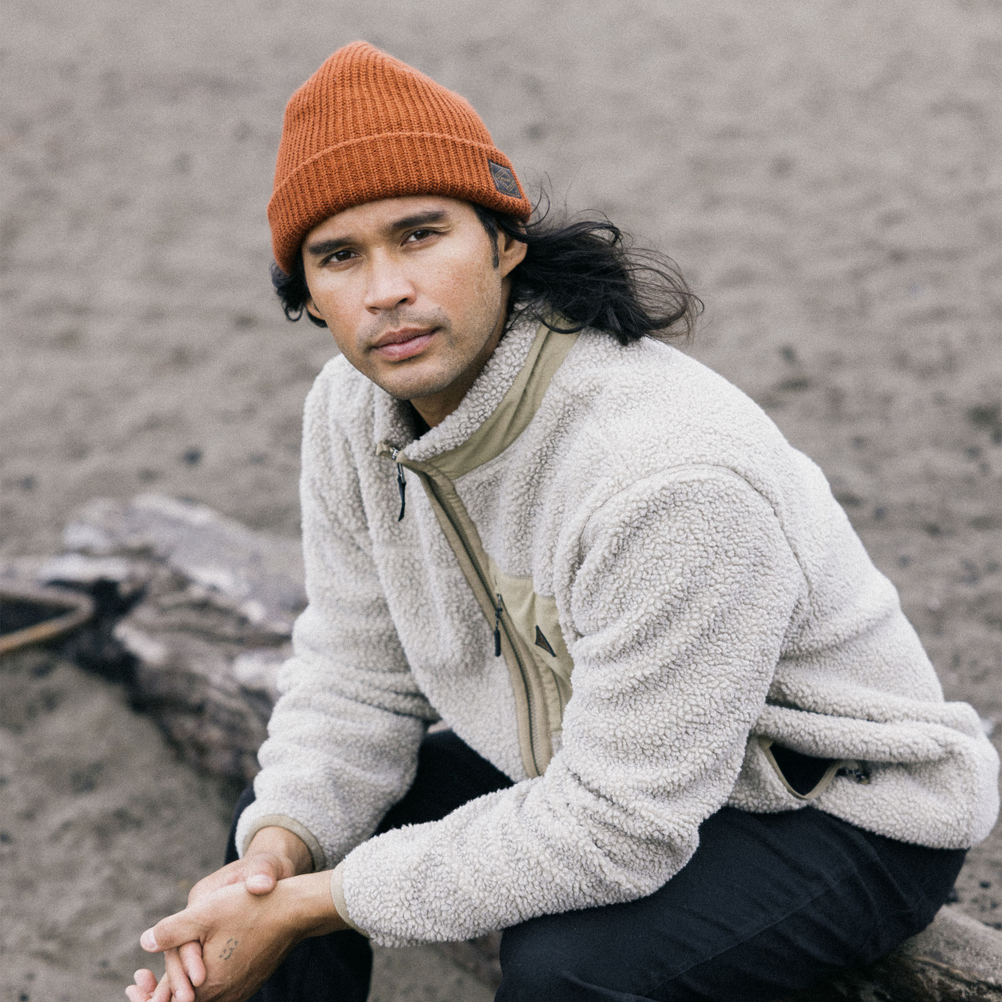 Person wearing a Campover Fleece Zip Hoodie and a knit cap, ready for outdoor adventure in chilly weather, showcasing Roark's commitment to durable, travel-inspired fashion.