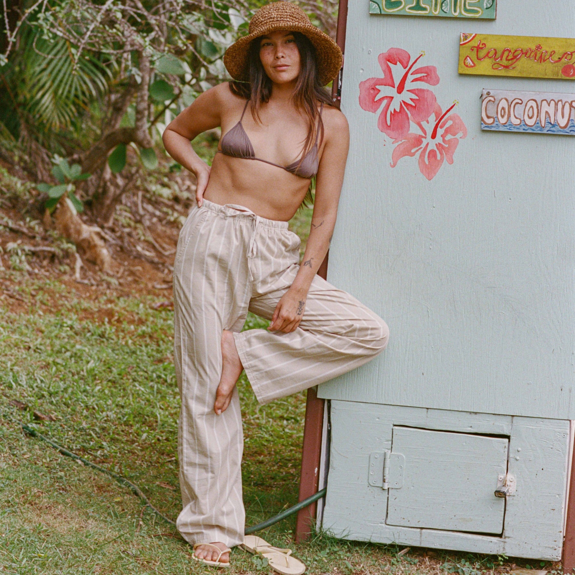 Model showcasing Costa Pants during an outdoor photoshoot in a natural setting, emphasizing adventure and travel style.