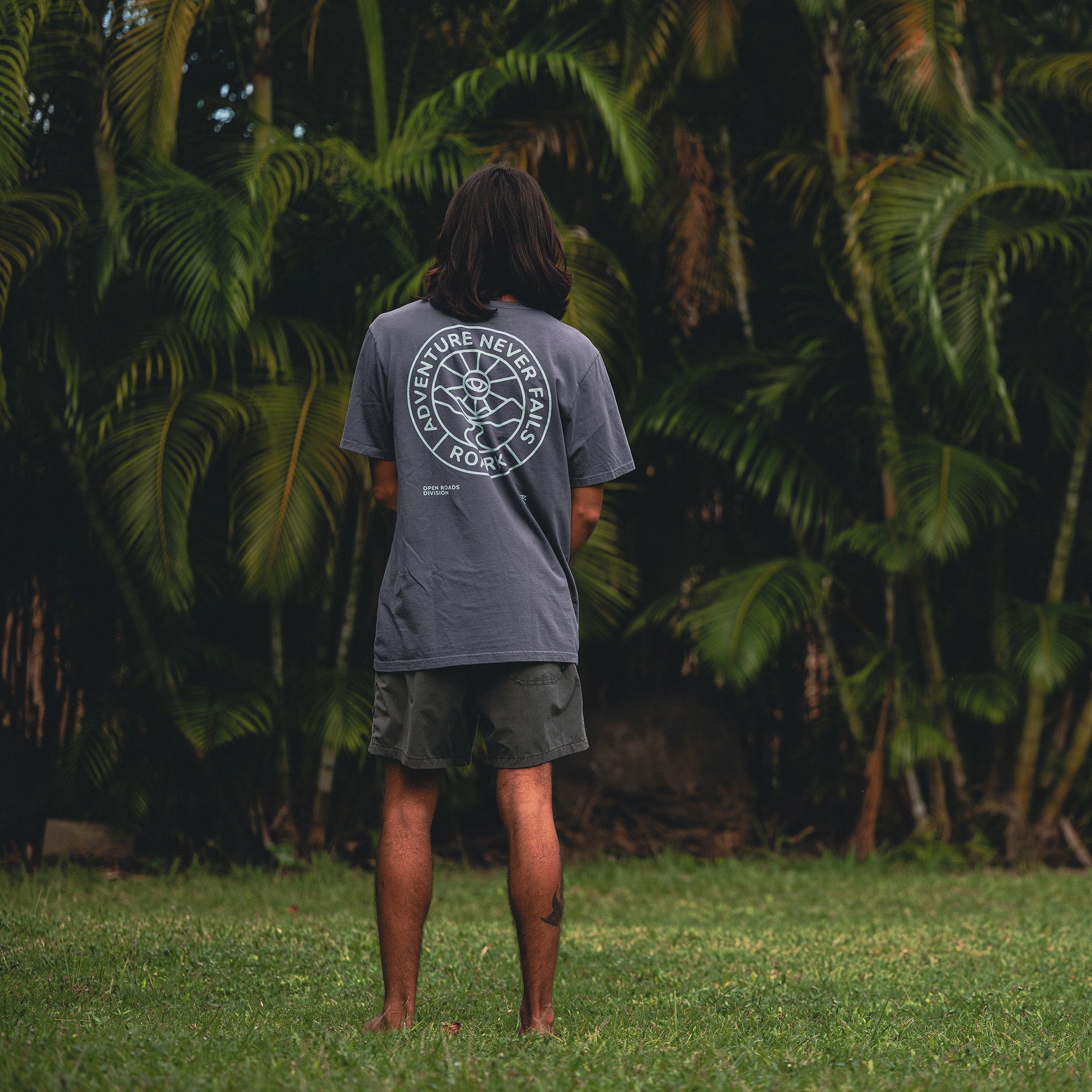 Person wearing Roark Division Premium Tee standing in a scenic outdoor setting, embodying an adventurous spirit.
