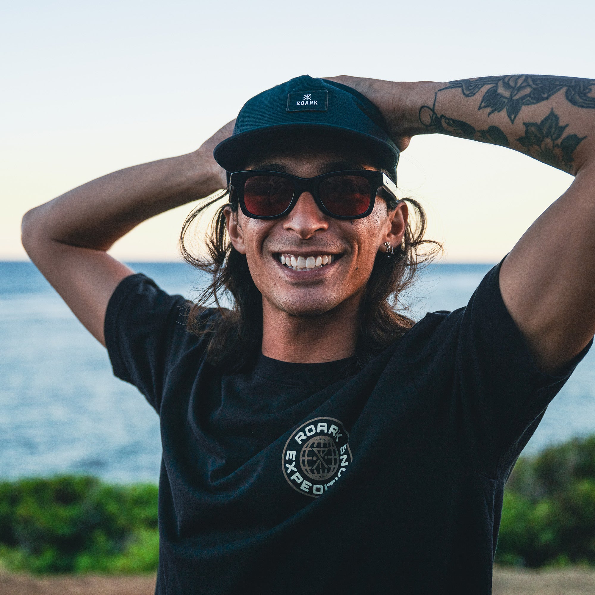 Man wearing a Roark Division Premium baseball cap and active shirt, styled for comfort and adventure
