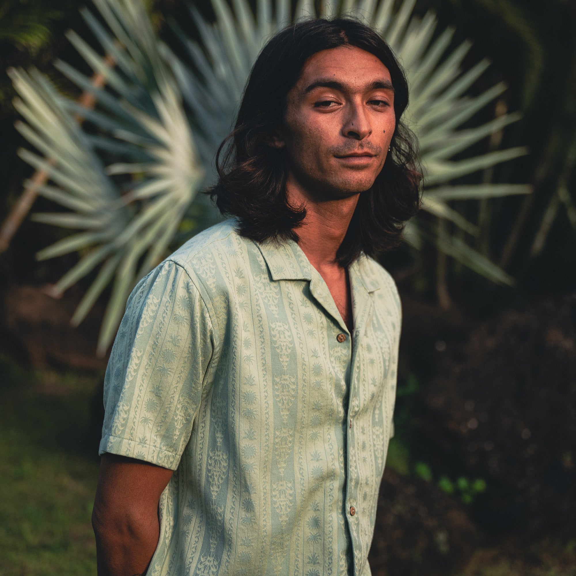 Man wearing a Gonzo short sleeve button-up shirt outdoors, exploring nature with visible shirt details like collar and buttons, embodying Roark's spirit of adventure and travel.