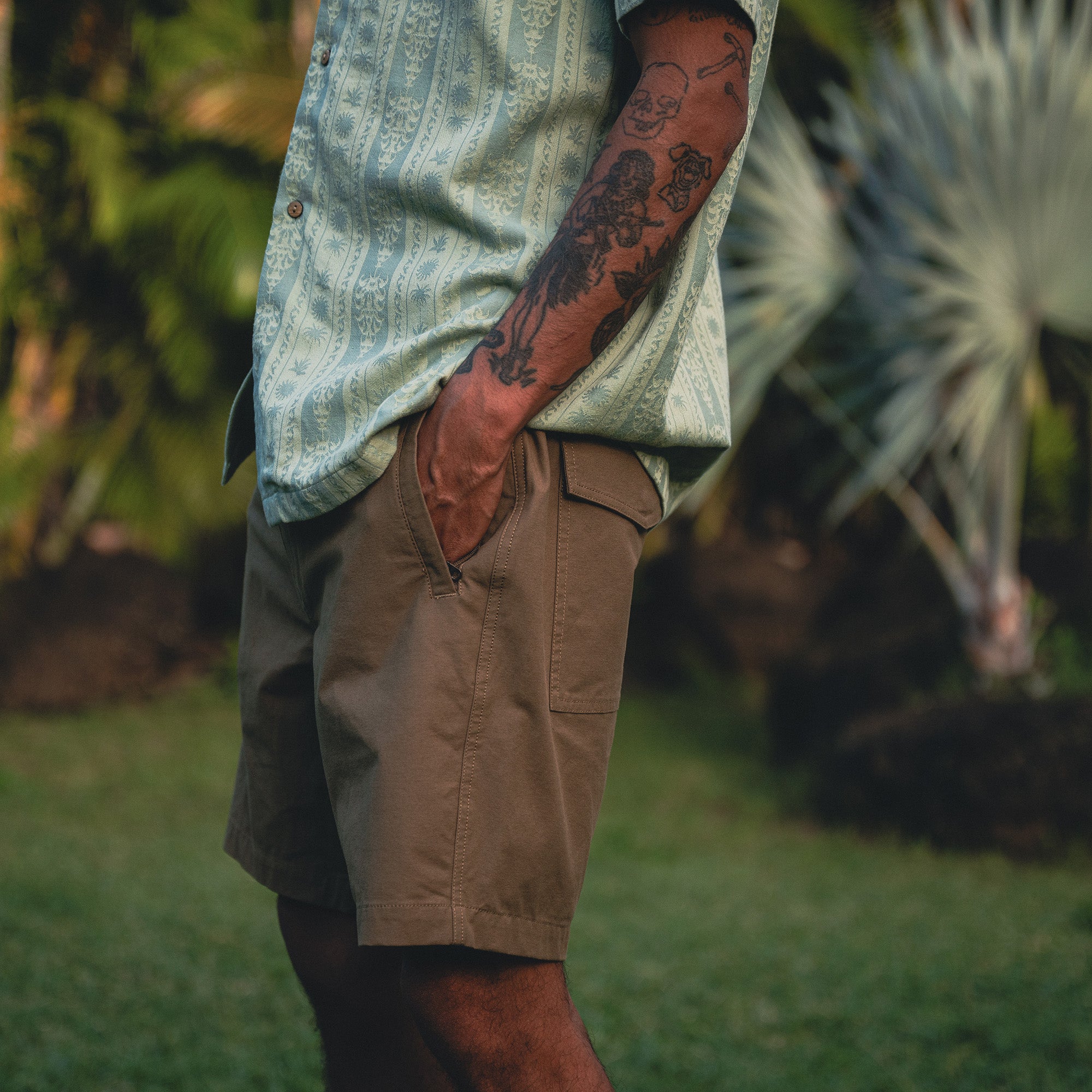 Model showcasing the versatile Roark Gonzo Short Sleeve Button-Up Shirt SP26 14, styled with casual shorts perfect for adventure and travel.