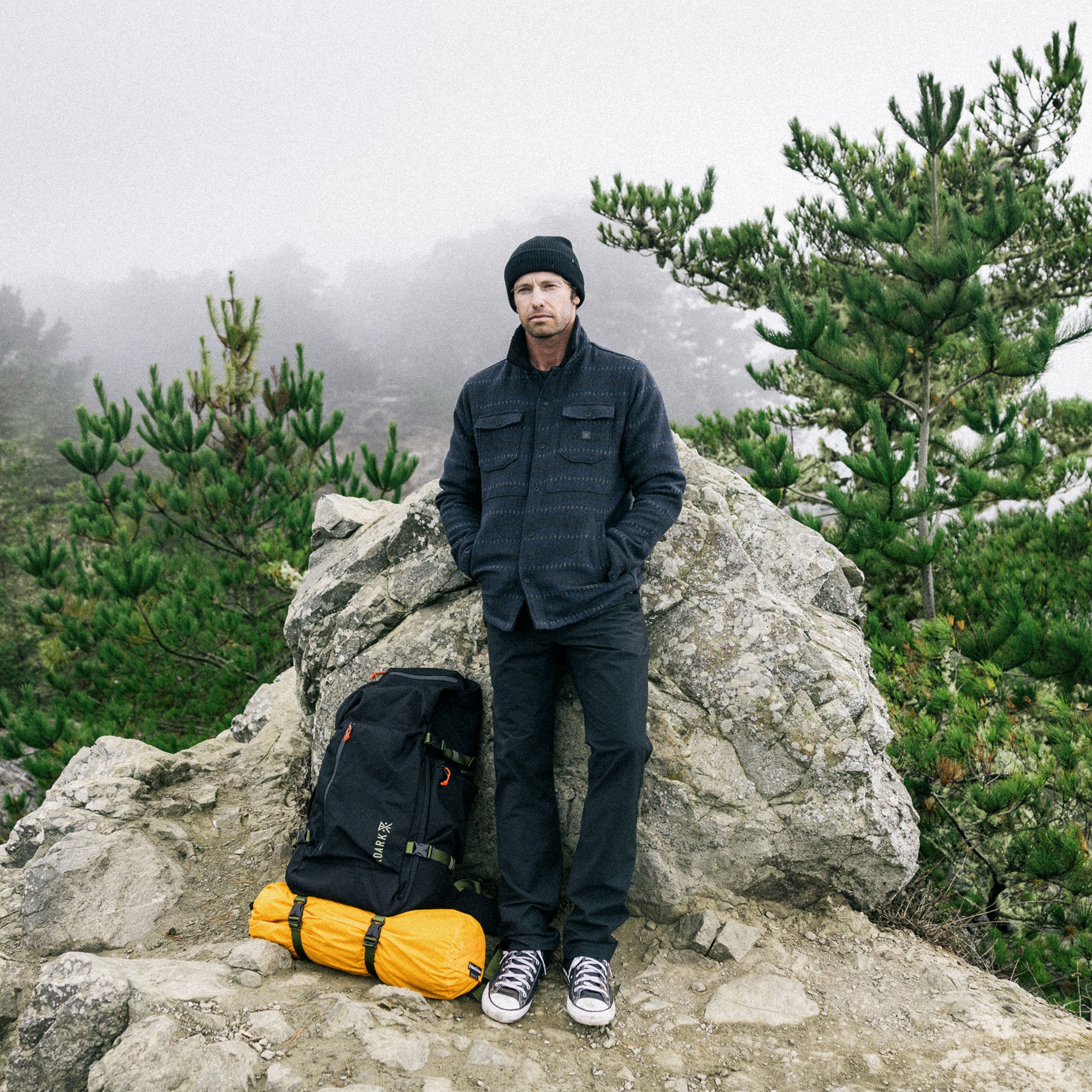 Adventurous person with backpack exploring the outdoors, exemplifying the spirit of Roark's Hebrides Jacket HO25 5 design.
