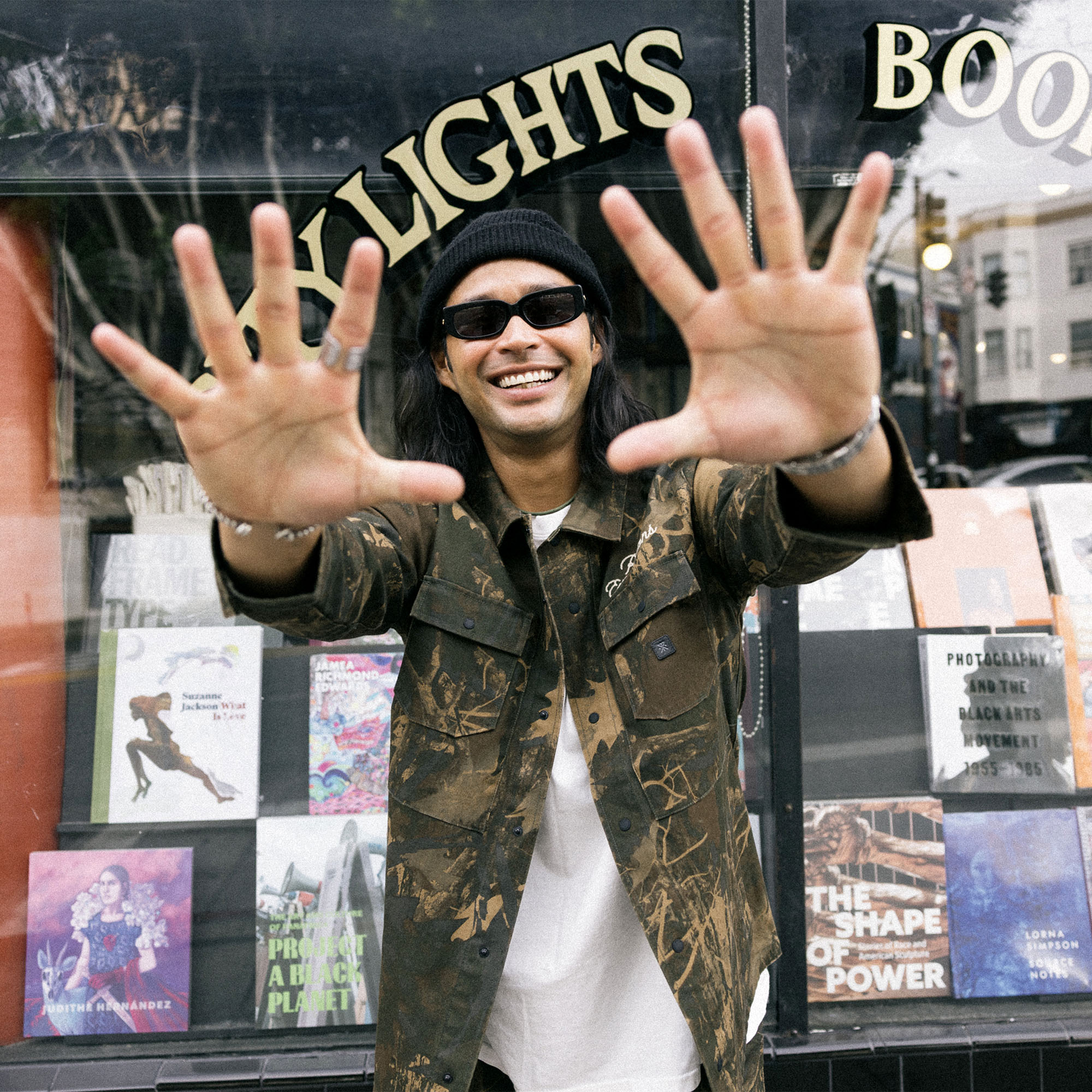 Smiling adventurer wearing a Hebrides Unlined Jacket and cap, embodying happiness and outdoor style