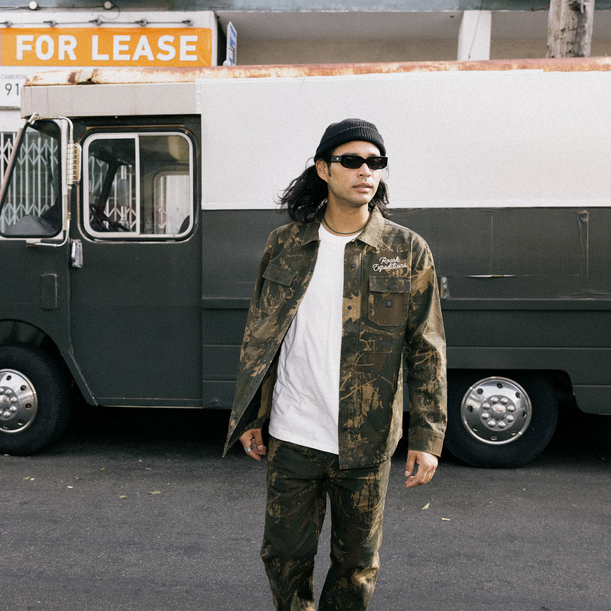 Stylish Hebrides unlined jacket featuring military camouflage pattern, paired with rugged denim and cargo pants for outdoor adventures.