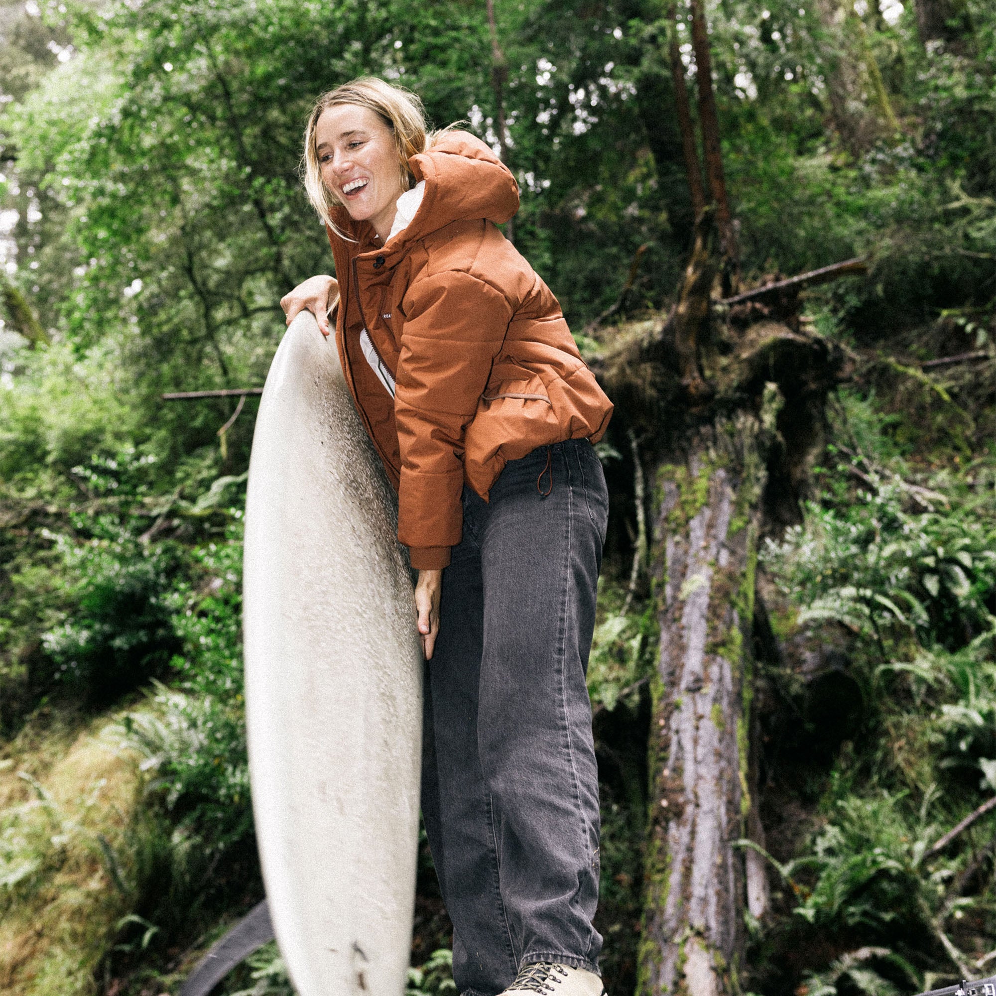 Blond adventurer wearing a Roark Hokkaido Puffer Jacket with hood, exploring a snowy winter landscape.