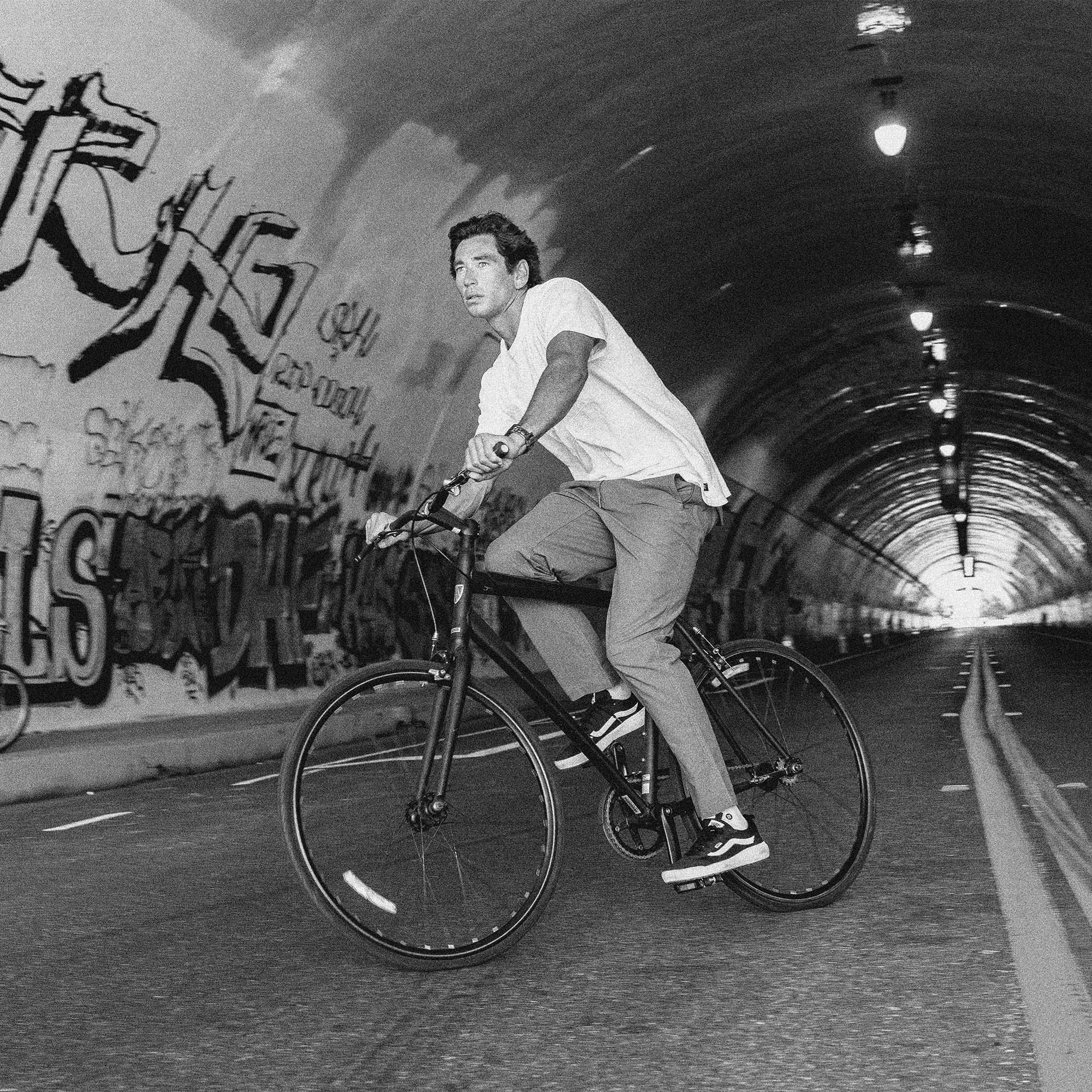 Versatile Layover Pro Pants showcased in an adventurous setting with a bicycle, highlighting their suitability for active travel and outdoor activities.