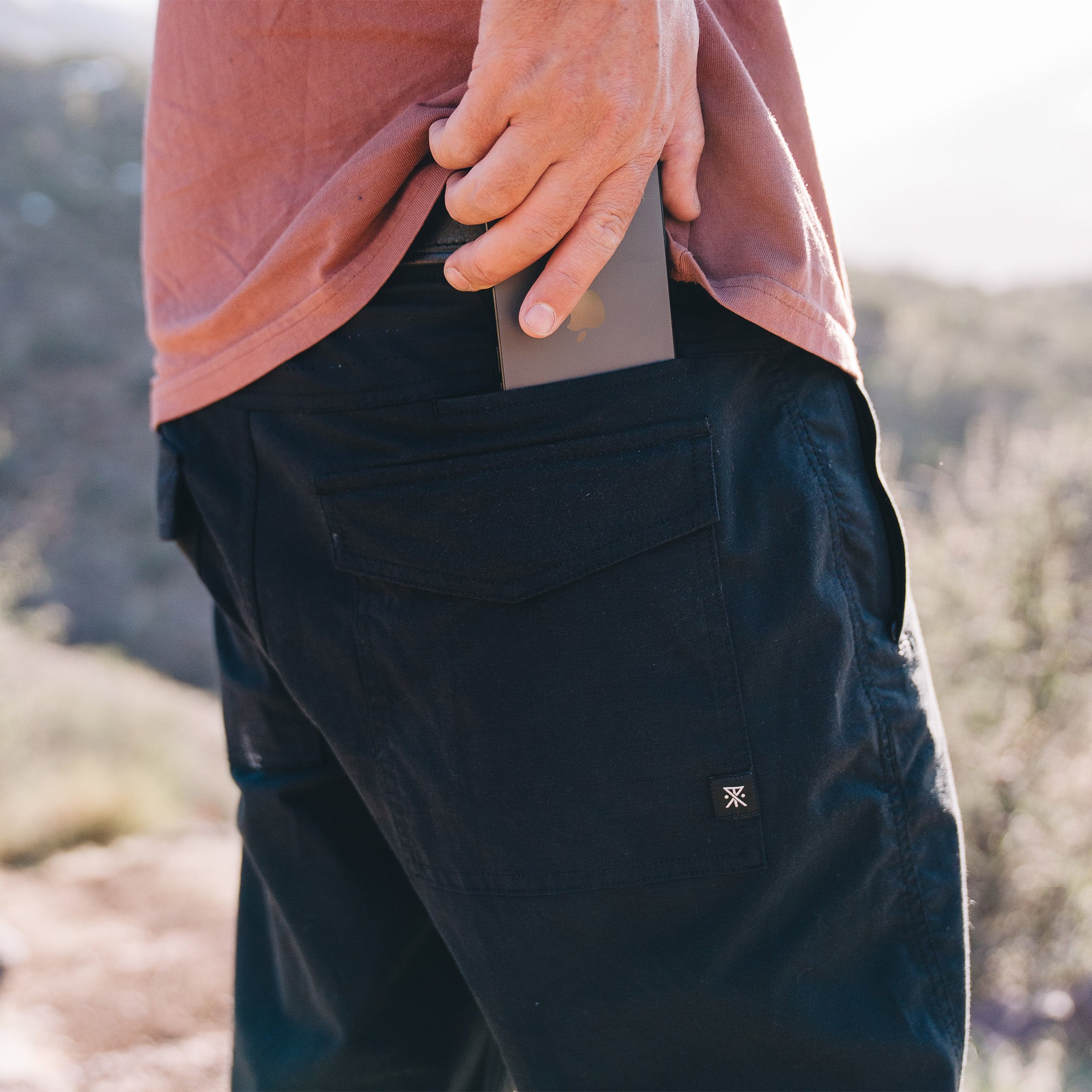 Group of adventurers wearing Roark Layover Pro Pants exploring rugged bedrock terrain on a hiking trip