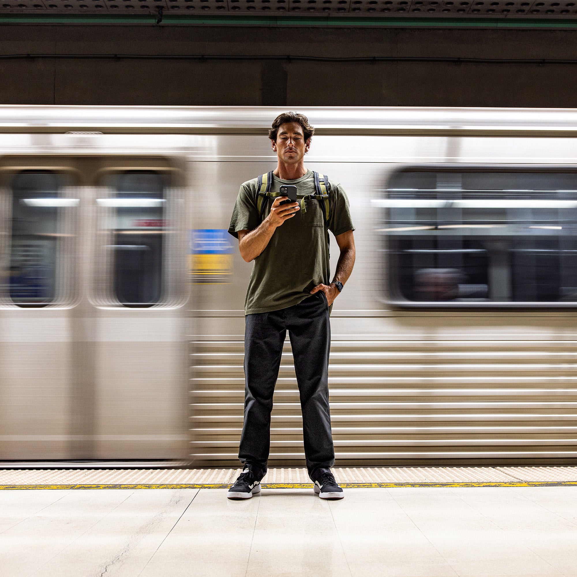 Man standing in an adventurous setting showcasing the durability and style of Roark's Layover Pro Pants, paired with sneakers