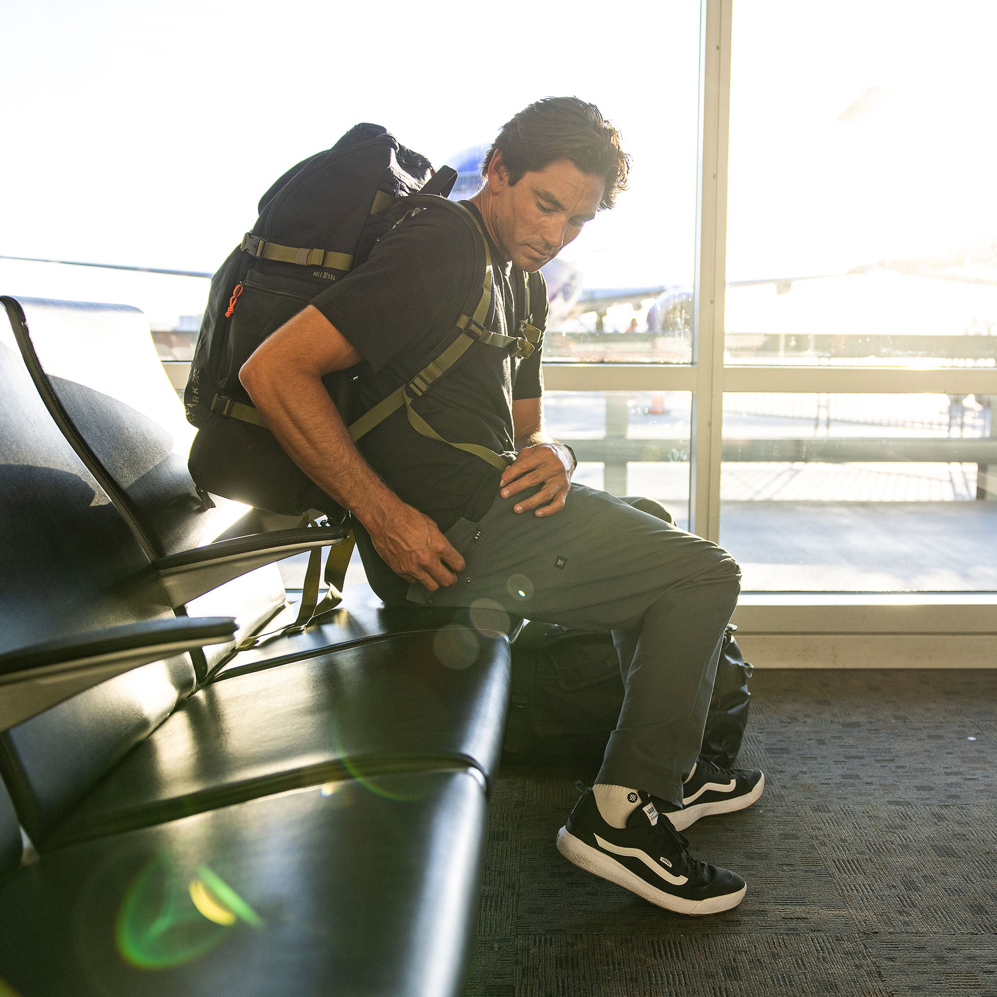 Travel-ready scene featuring the versatile Layover Pro Pants FA25, with a stylish black bag, shoes, and backpack arranged for an adventurous journey.