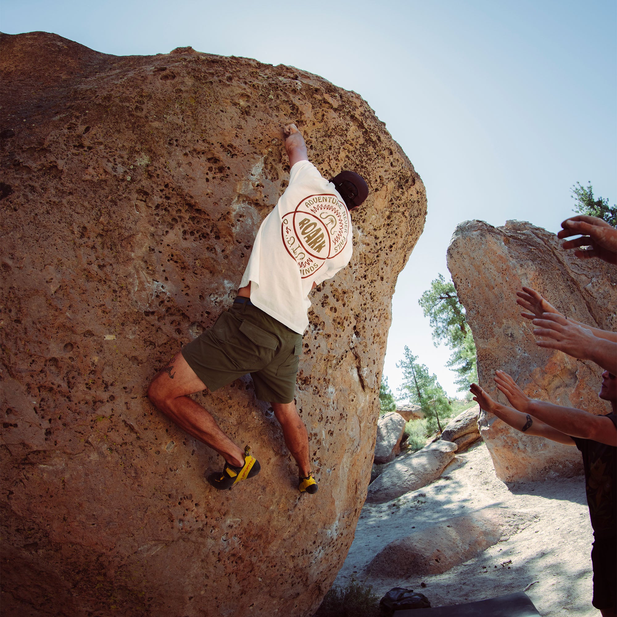 Man climbing rocky terrain in Layover Pro Shorts, exemplifying adventure and outdoor recreation.
