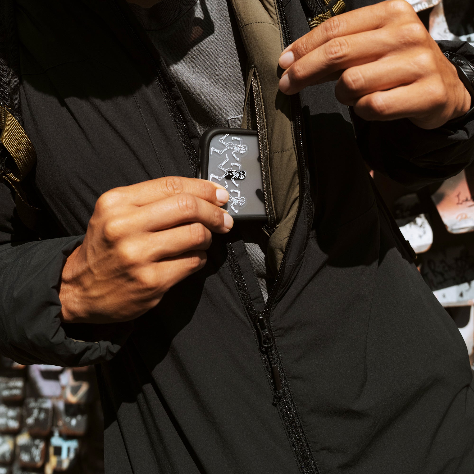 Roark Layover Jacket in black worn by model, showing zippered pocket detail and khaki interior lining in lifestyle shot