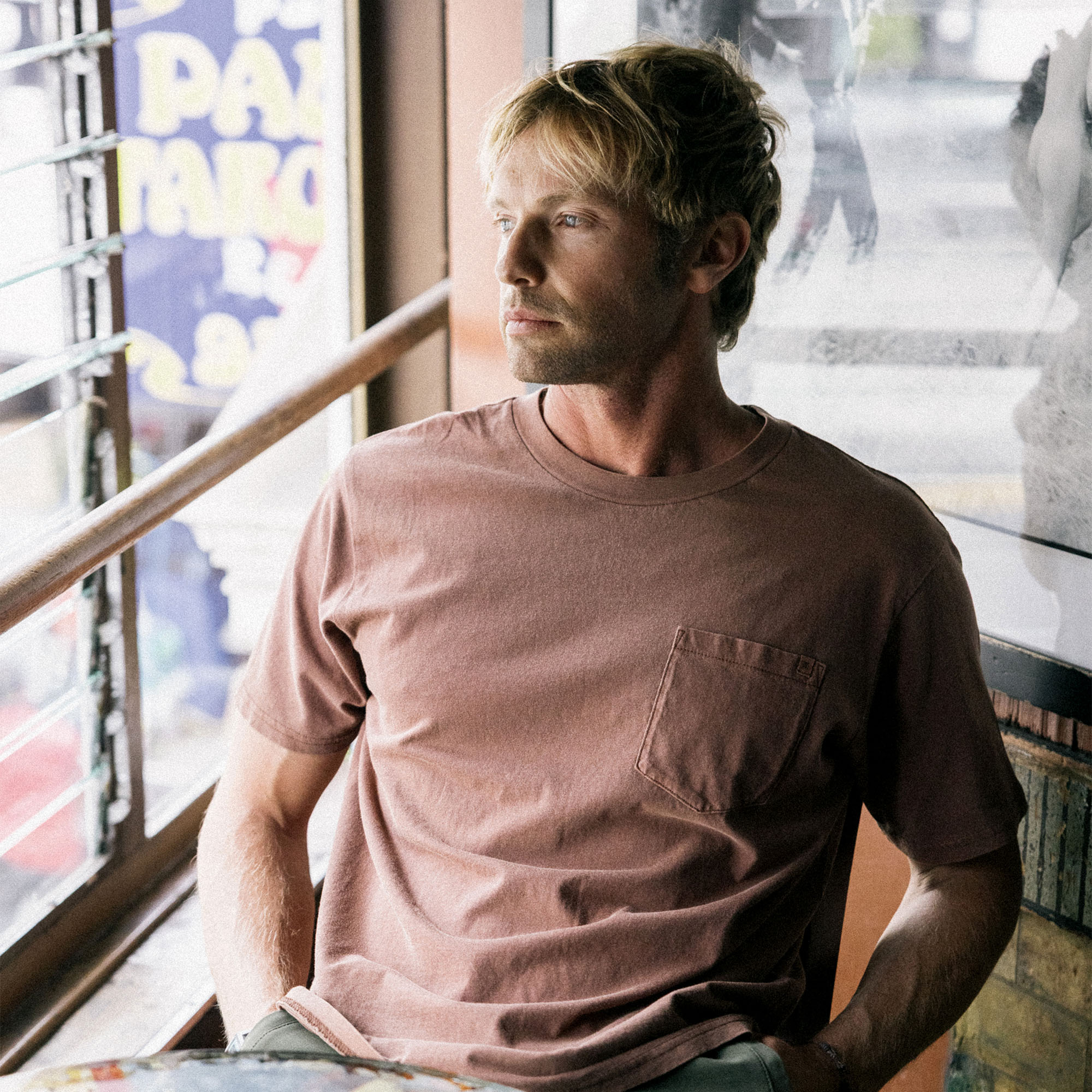 Model wearing a versatile Roark MTF T-shirt, ideal for outdoor adventures and travel, featuring a comfortable fit and casual style.