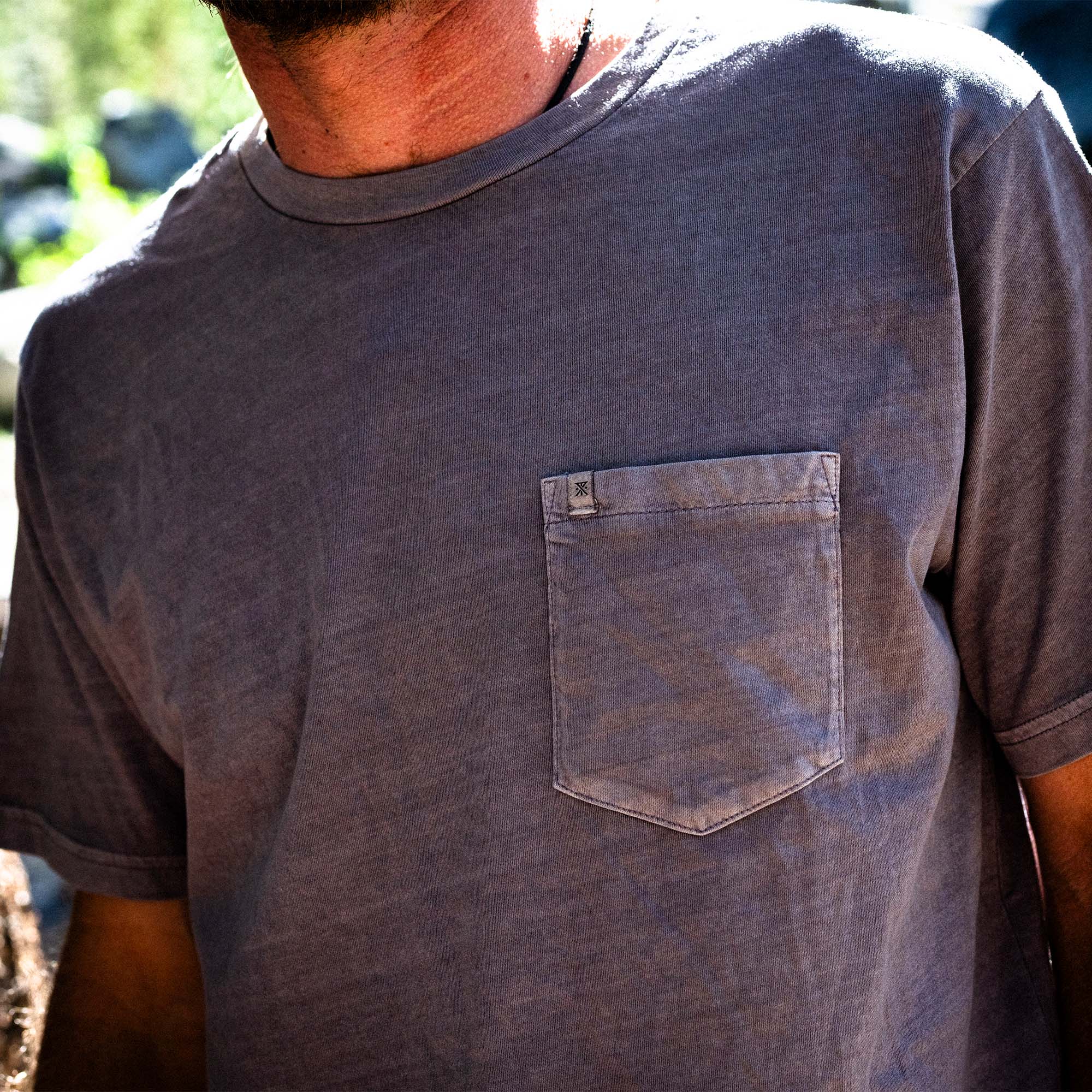 Man with a beard wearing a Made to Fade Tee by Roark, styled with denim, embodying the adventurous and rugged outdoor lifestyle.