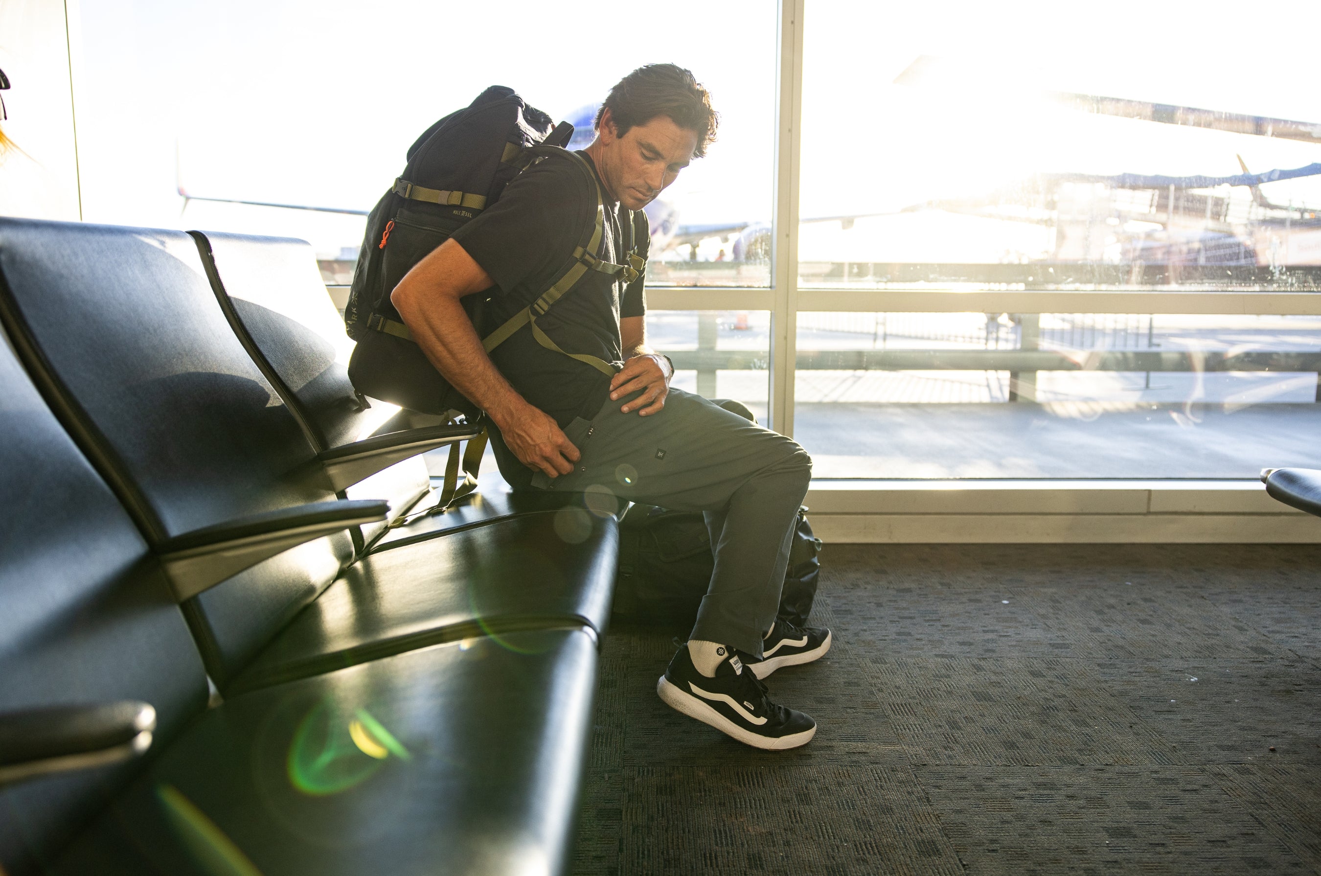 A traveler's assortment with a focus on mobility, featuring a rugged backpack, durable luggage, and sturdy shoes arranged on a cobblestone street, embodying the spirit of adventure.