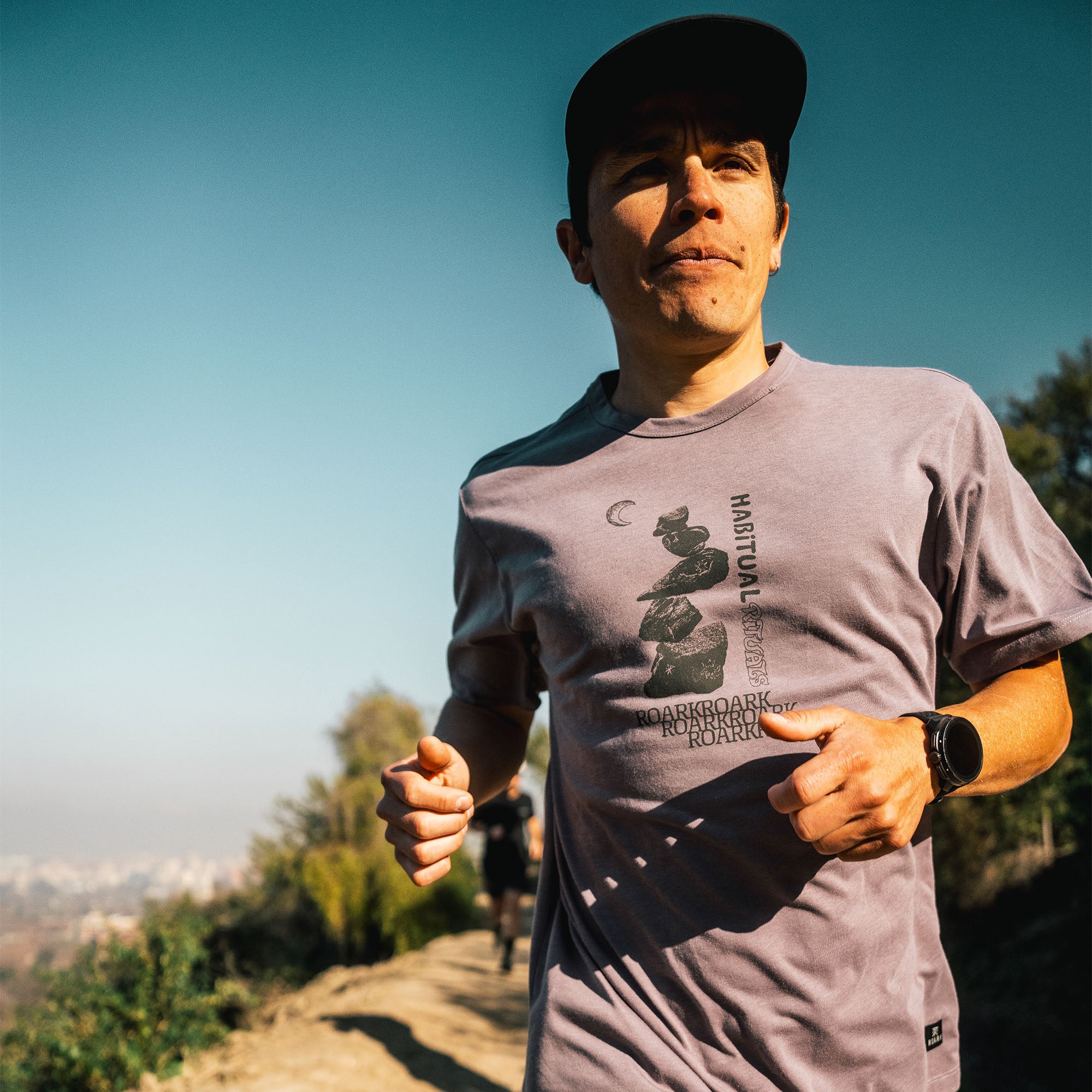 Active man wearing a Roark Mathis Active Short Sleeve Tee, perfect for outdoor adventures and travel, showing detail of the sleeve, shoulder, and neck design.