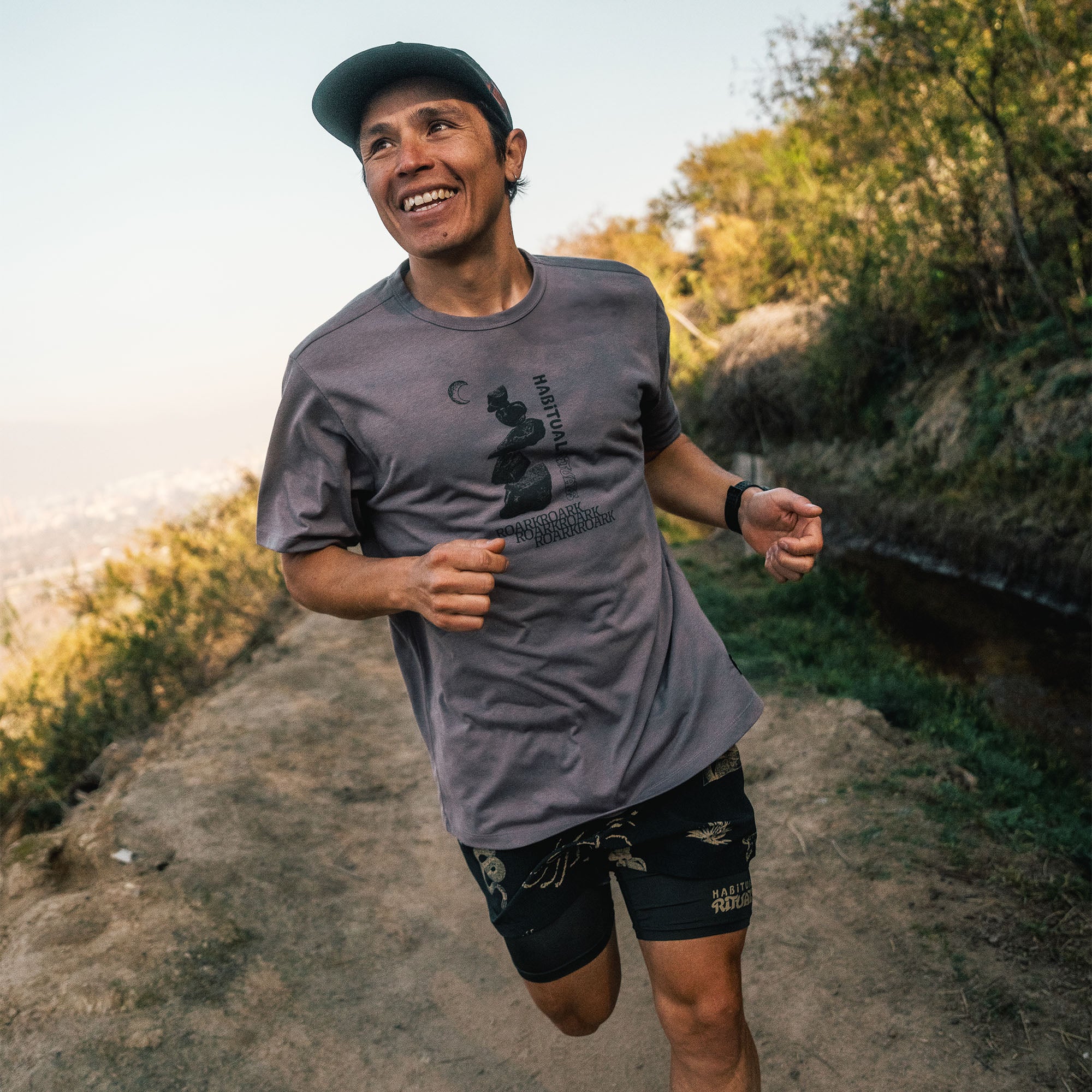 Man actively enjoying the outdoors wearing Roark's Mathis Active Short Sleeve Tee and shorts, complete with a sporty hat for sunny adventure days.