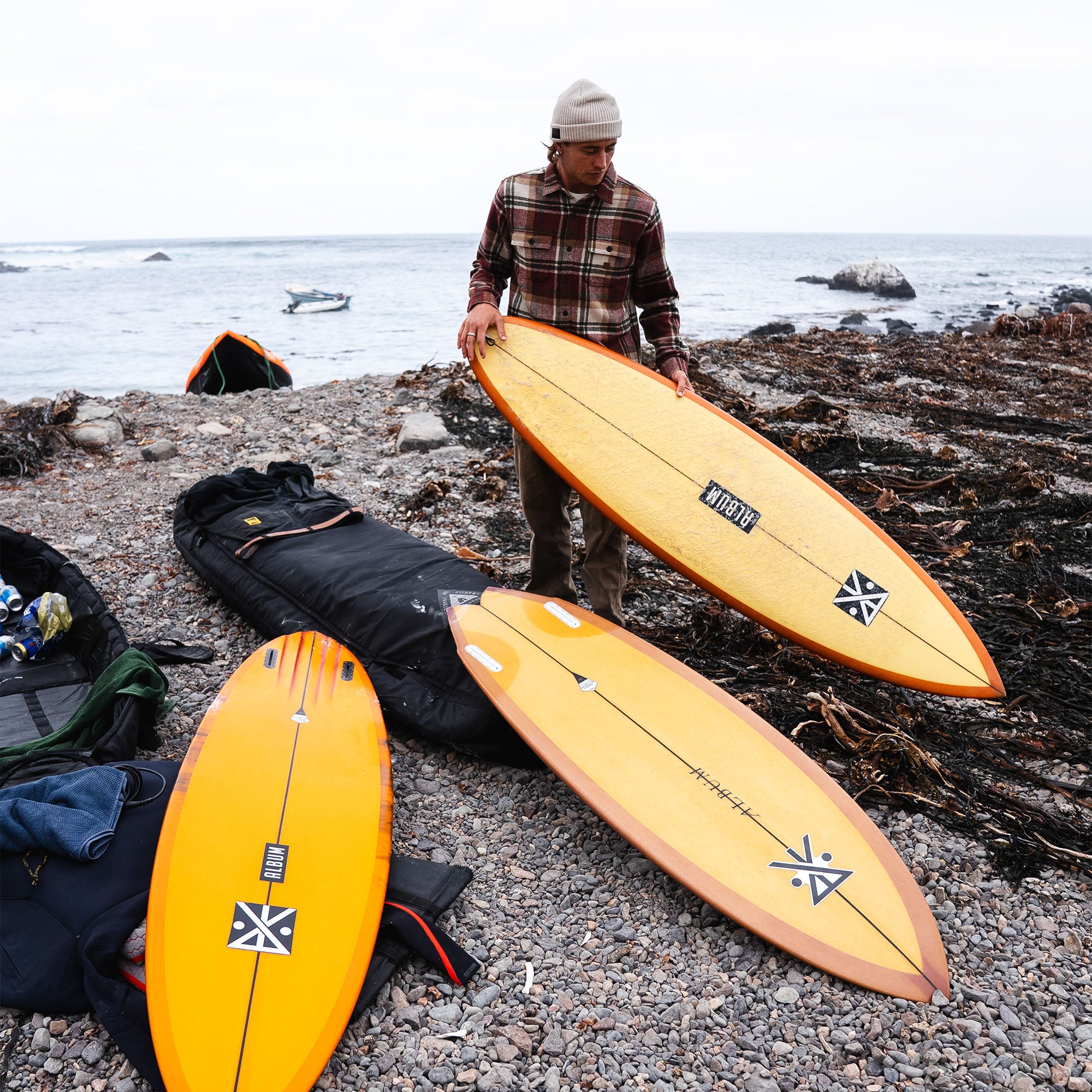 Surfboard and surfing gear laid out on the beach, showcasing the adventurous spirit ideal for wearing Roark’s Nordsman Long Sleeve Flannel.