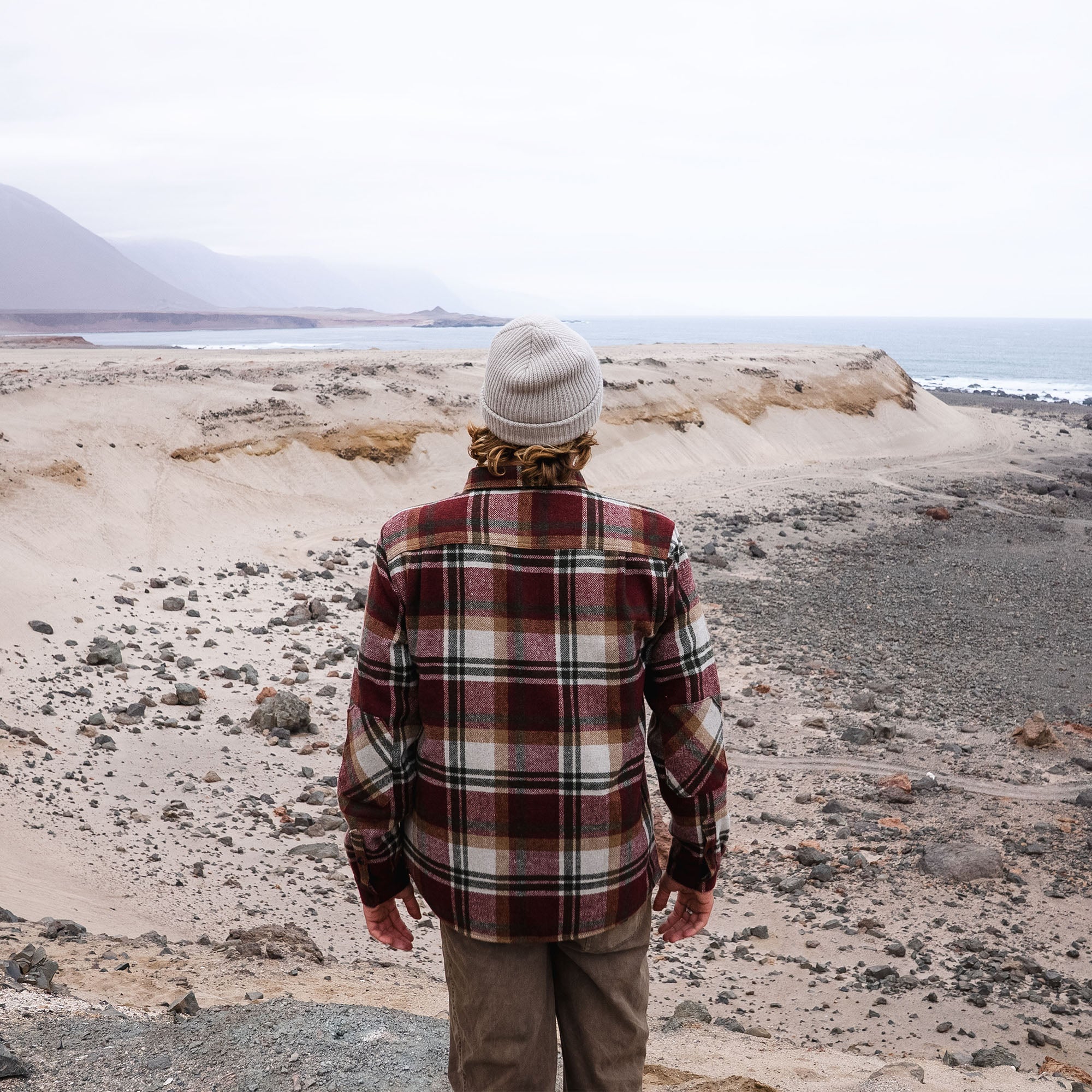 Roark Nordsman Long Sleeve Flannel in a rugged winter landscape, blending into a background of rocks and rubble