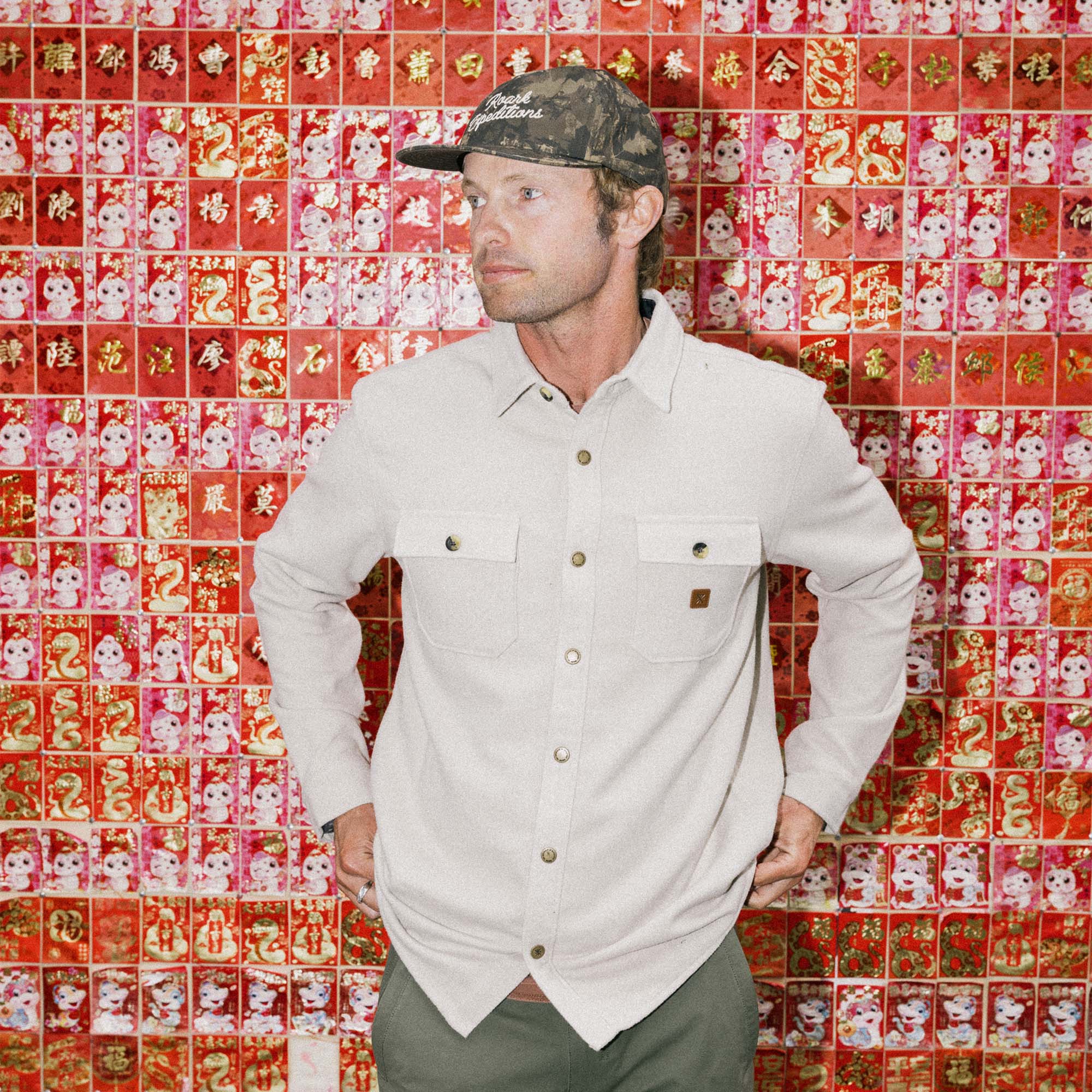 Man wearing Roark Nordsman Long Sleeve Flannel, styled with a sun hat, showcasing the rugged adventure-ready design perfect for travel and outdoor activities.