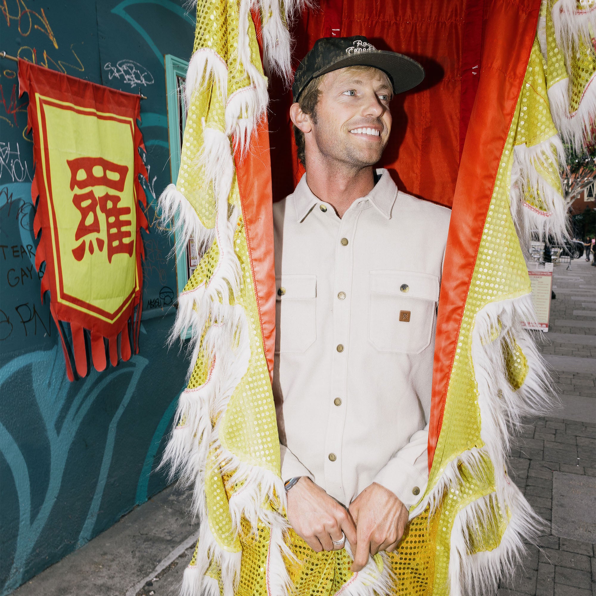 Happy individual in outdoor setting wearing a stylish hat, exuding a sense of adventure and happiness, suitable for showcasing Roark’s travel-inspired lifestyle.