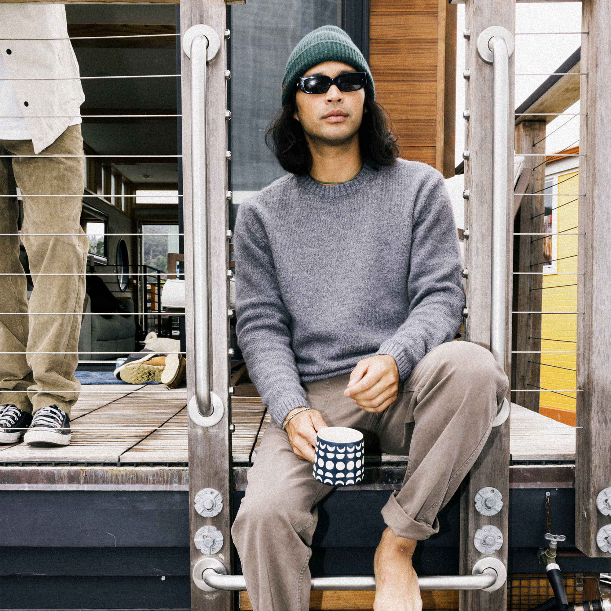 Model in rugged outdoor setting wearing Roark Nordsman Wool Sweater paired with denim jeans and active pants, exemplifying adventure-ready fashion.