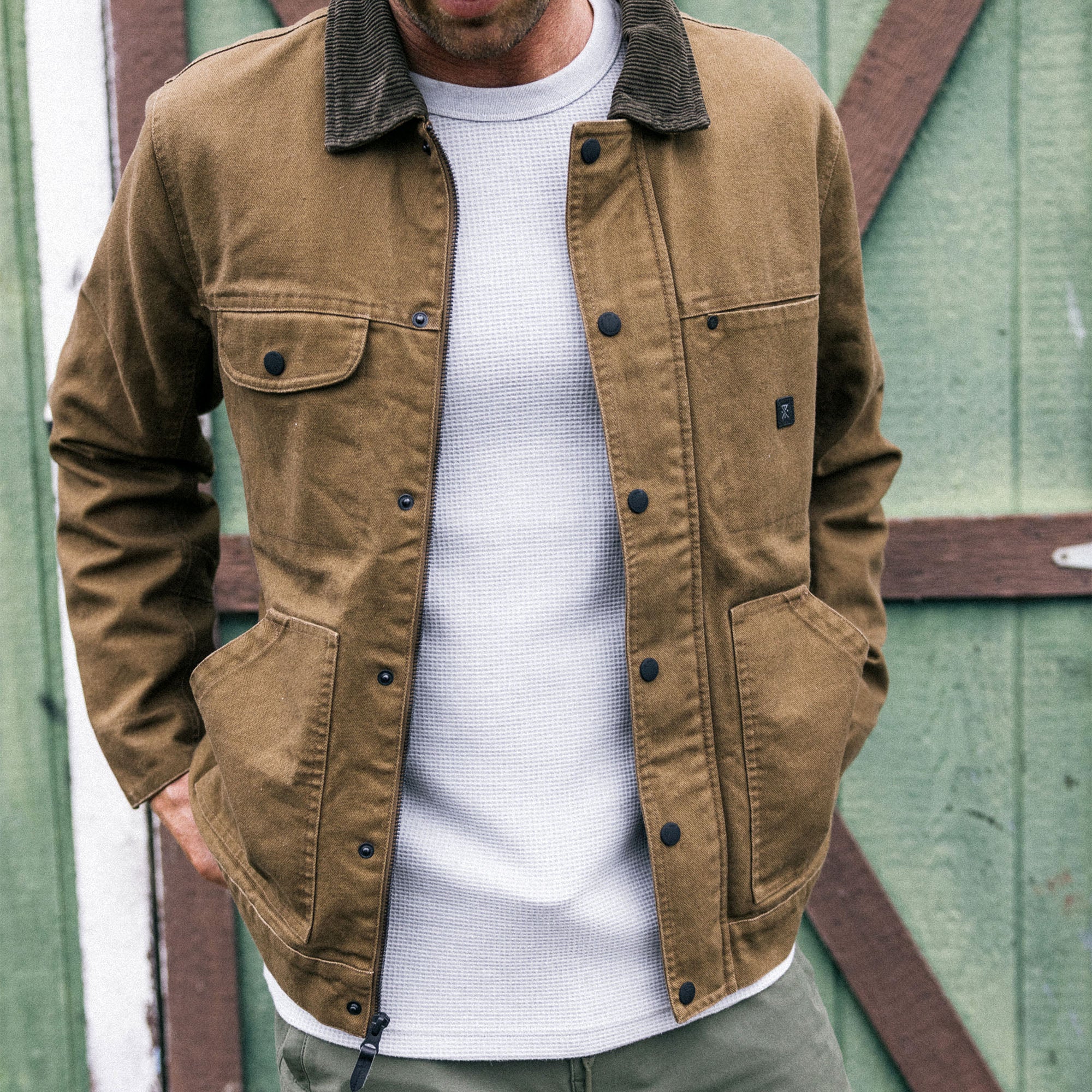 Waxed canvas jacket from Roark's Open Roads collection, designed for outdoor adventure and travel, in a rugged outdoor setting