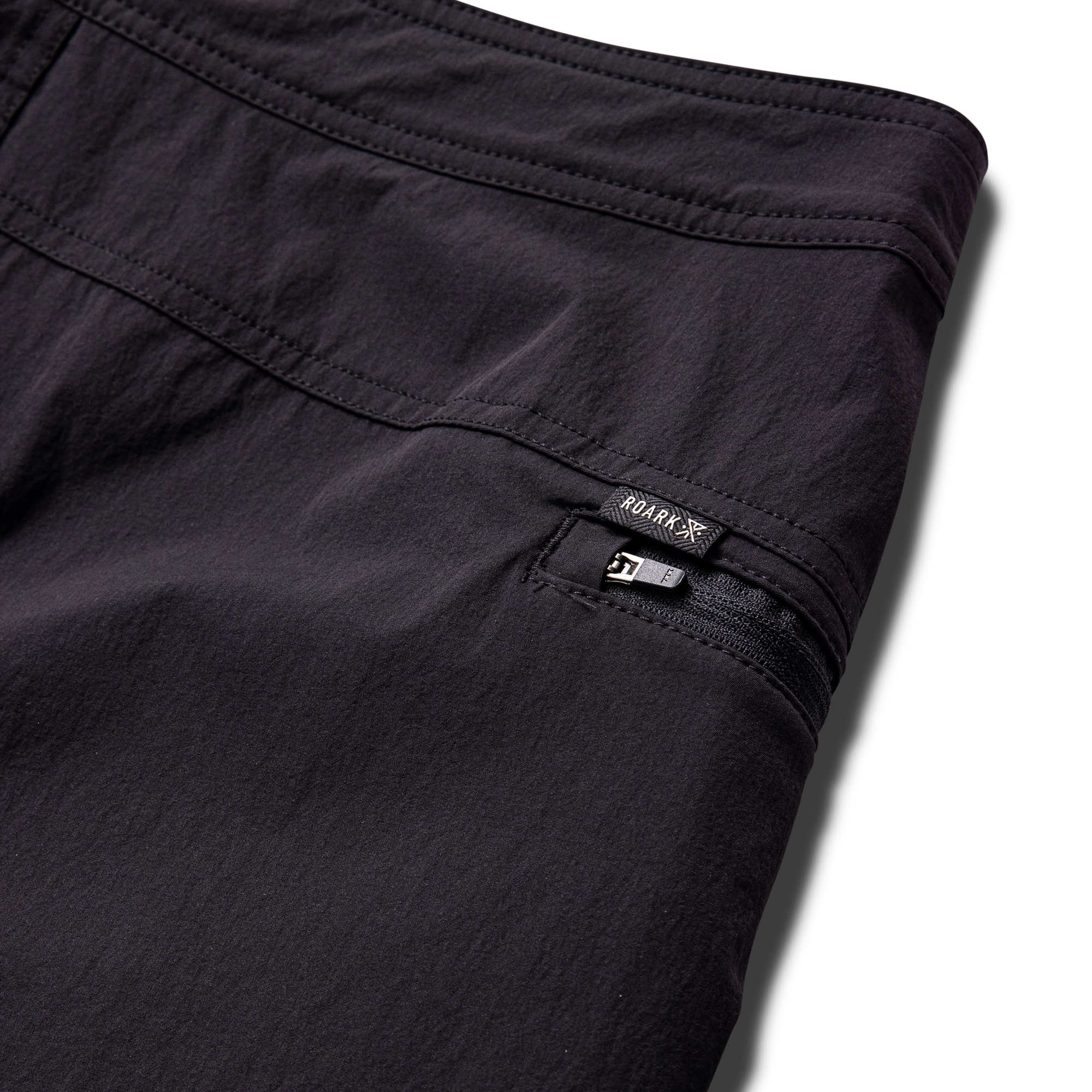 Close-up view of a textured black fabric from Roark's adventure gear collection, emphasizing durability and style for outdoor activities.