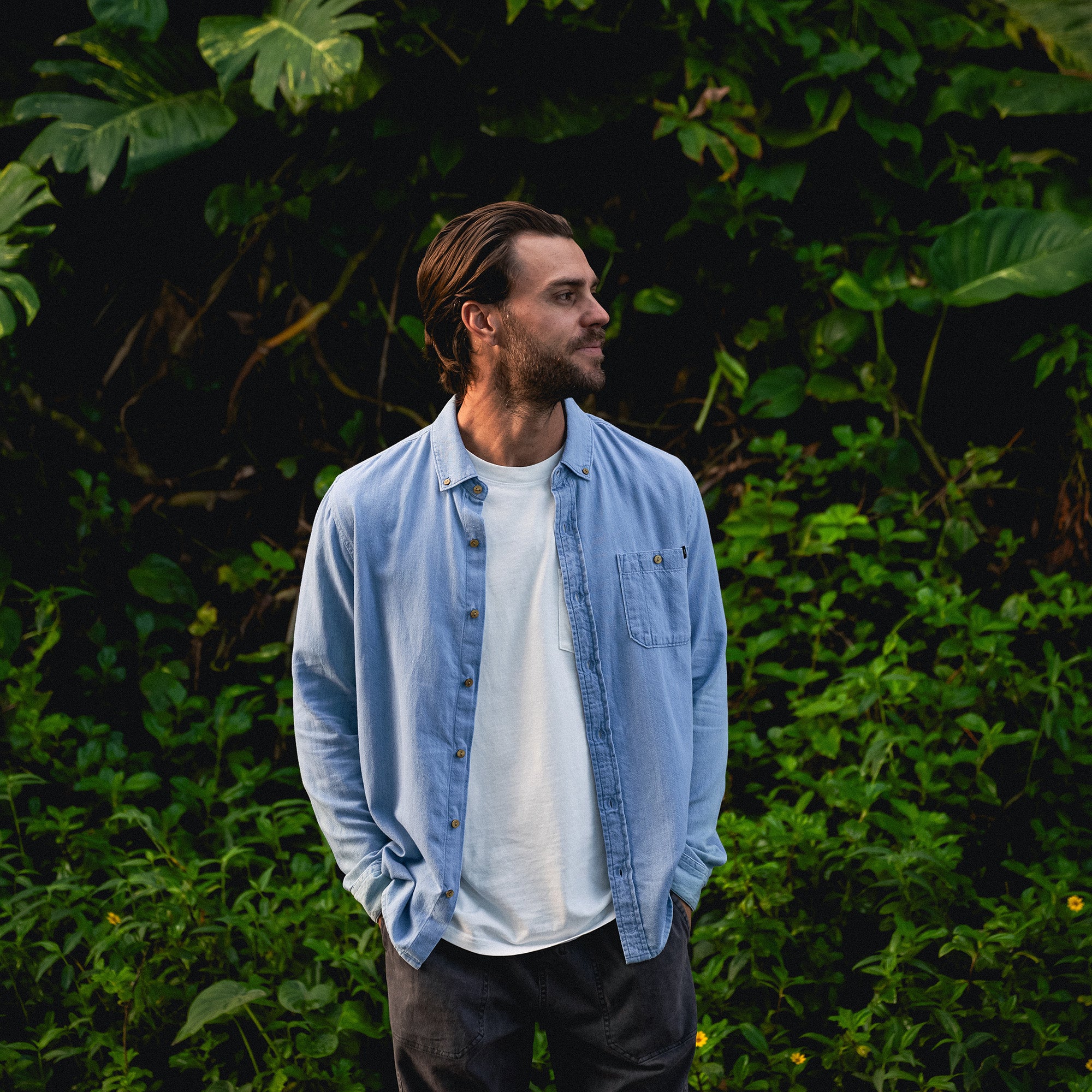 Close-up of a blue Scholar Chambray button-up shirt featuring durable denim fabric, detailed stitching on the collar and sleeves, and sturdy buttons, ideal for travel and outdoor adventures.