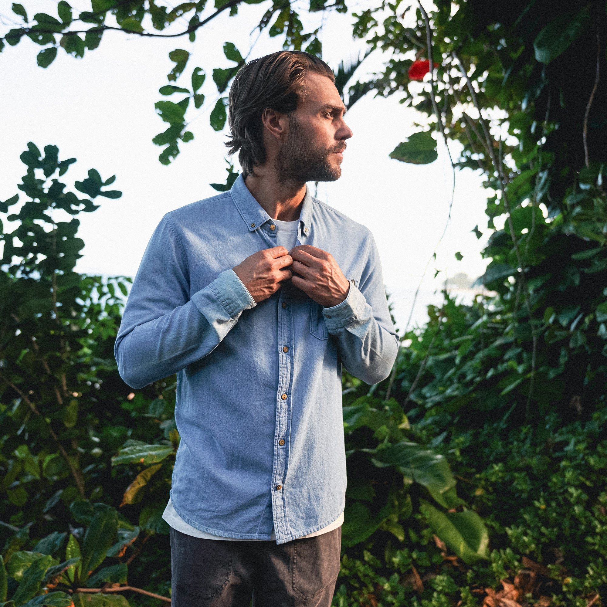 Versatile Scholar Chambray button-up shirt featuring durable denim fabric with prominent collar and sleeve details, ideal for adventure and travel