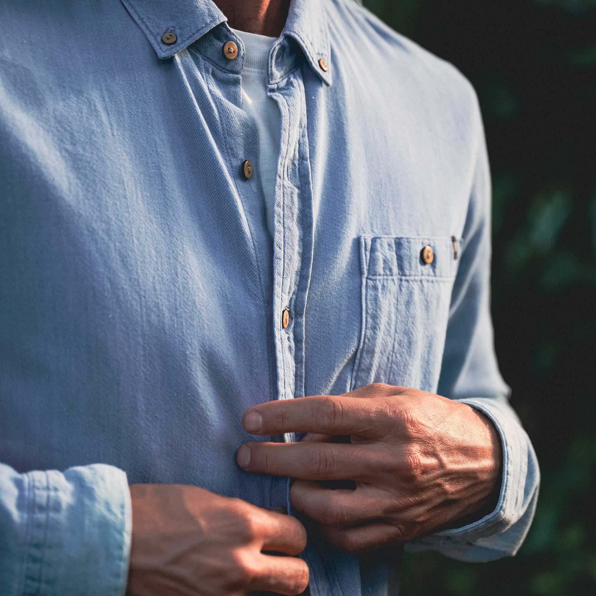Close-up of a Scholar Chambray button-up shirt featuring detailed blue textile, prominent collar, and sleek buttons, embodying Roark's adventure spirit in apparel design.