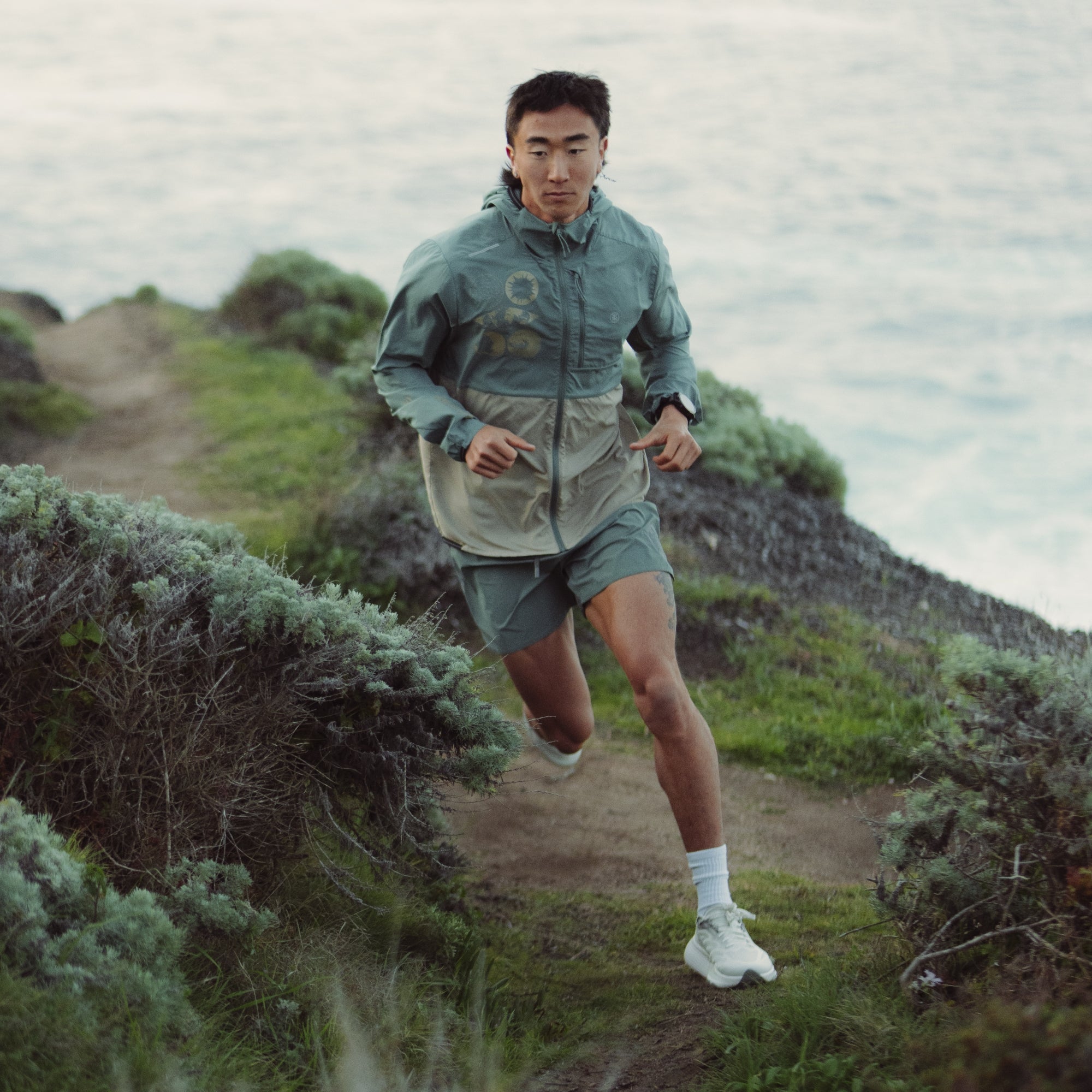 Runner wearing Roark Secondwind 3.0 Jacket on a trail, demonstrating mobility and comfort suited for individual outdoor sports