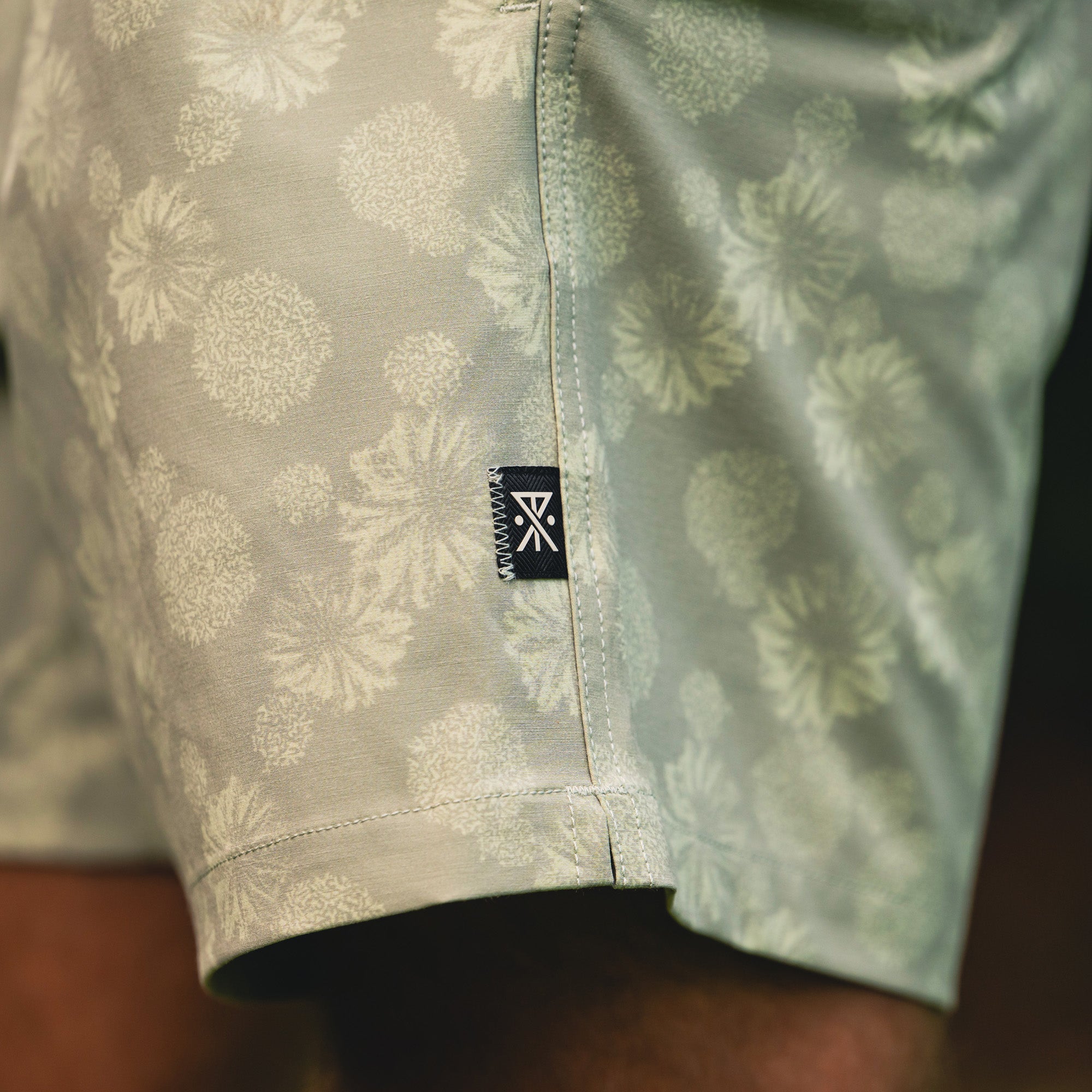 Man cliff-jumping into tropical waters wearing Roark Shorey Boardshorts.