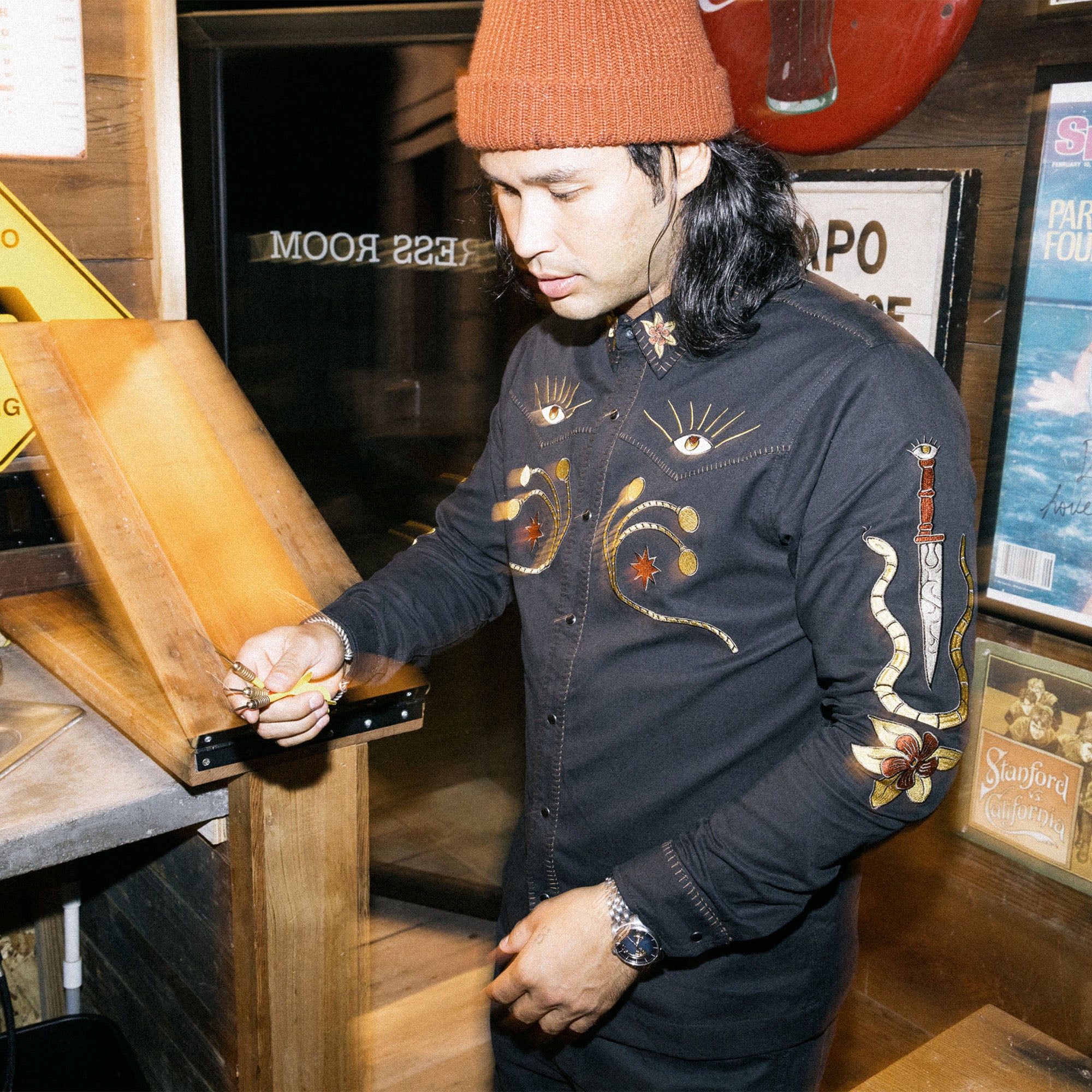 Rugged long sleeve denim Tierra del Sur shirt with button-up front, sleeves rolled up, detailed with pockets and a belt, perfect for adventure and outdoors.