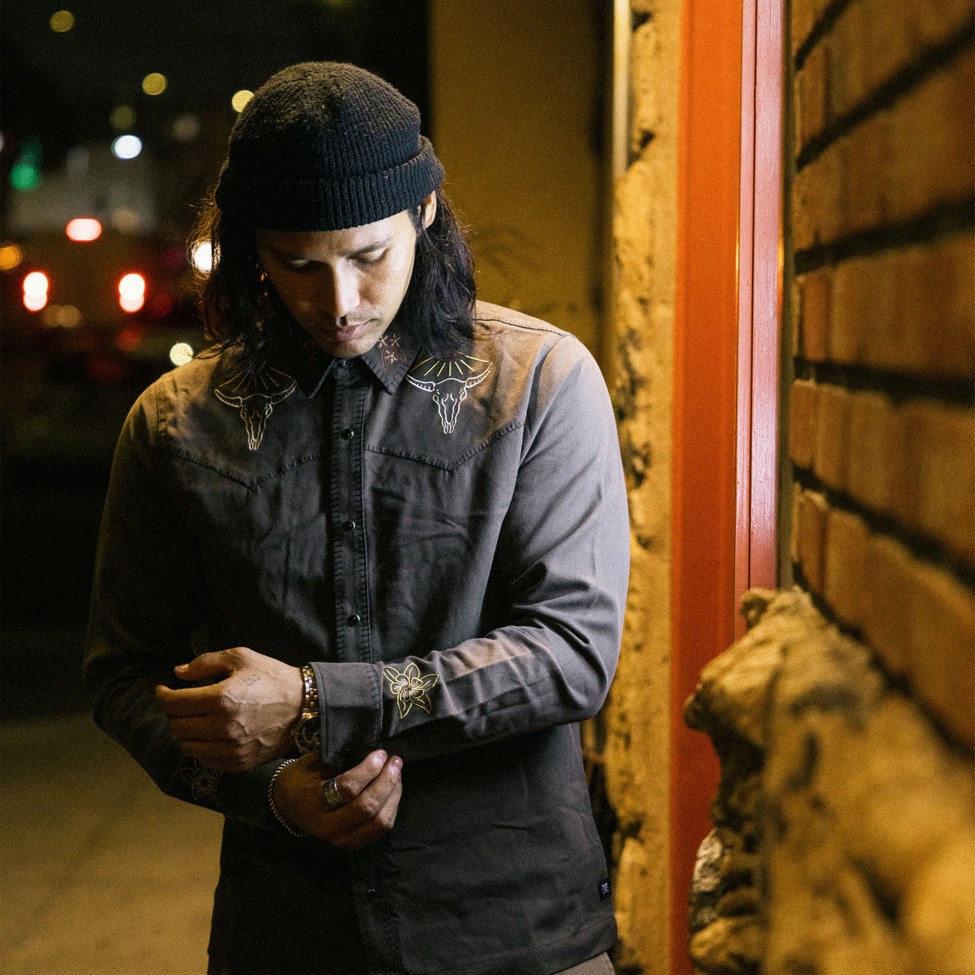 Stylish traveler wearing Roark's Tierra del Sur Range long sleeve button-up shirt paired with a denim cap