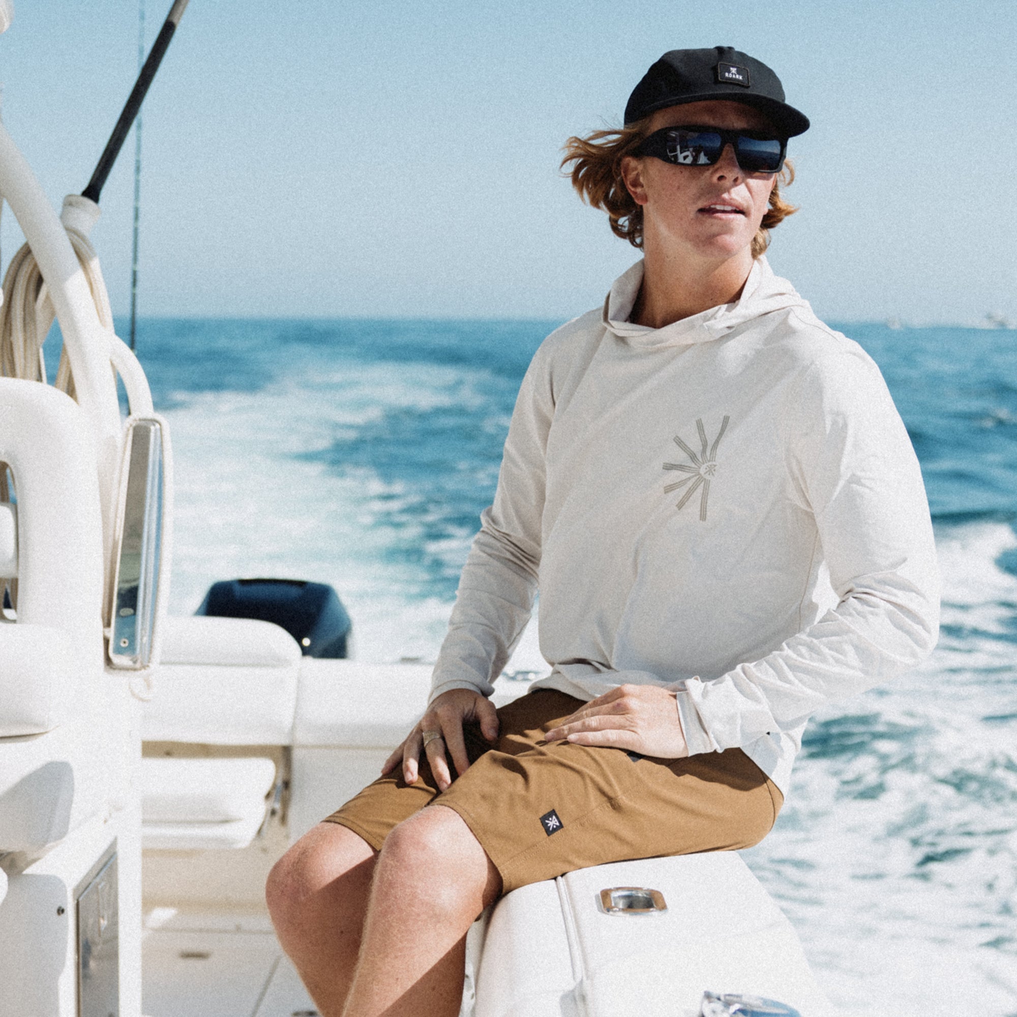 Group of friends enjoying a sunny day at the beach, one wearing a hat and stylish Roark Venture boardshorts, epitomizing leisure and fun.